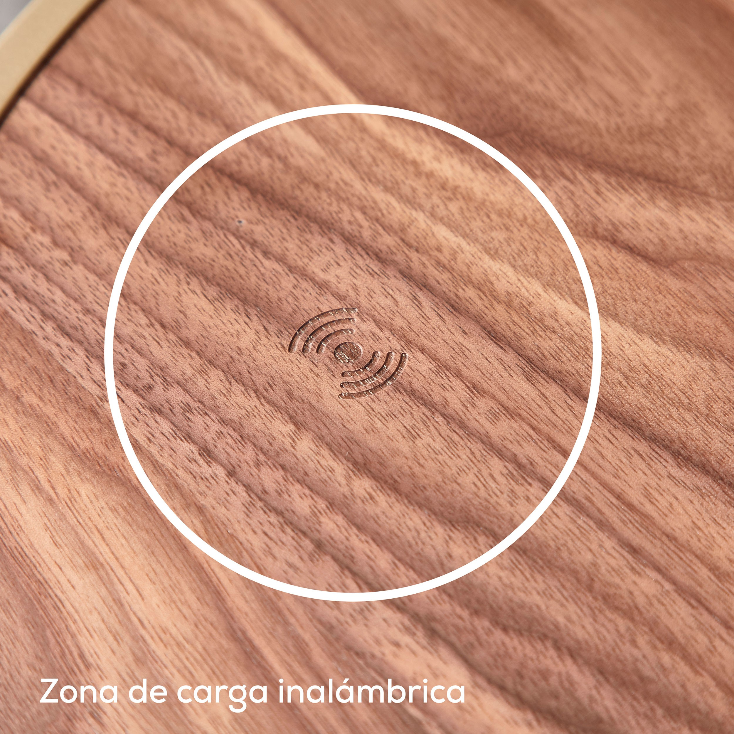 Superficie de madera con un círculo blanco, dentro del cual está grabado un símbolo de carga inalámbrica.
