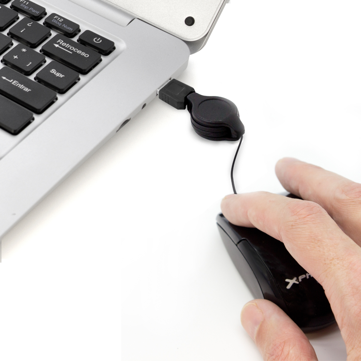 Un portátil con un ratón USB conectado. Una mano sostiene el ratón cerca del teclado.
