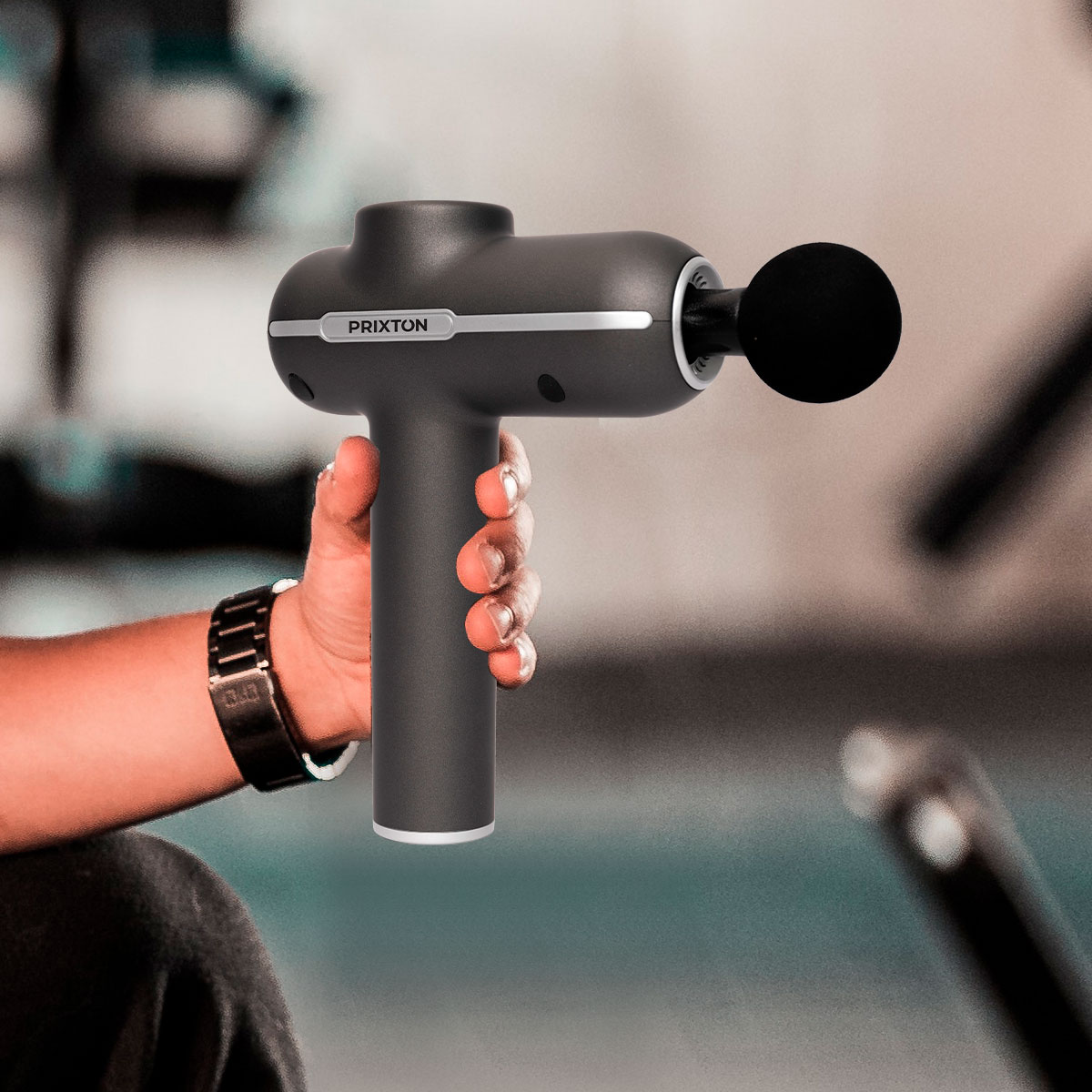 Dłoń trzymająca czarno-szary pistolet do masażu.