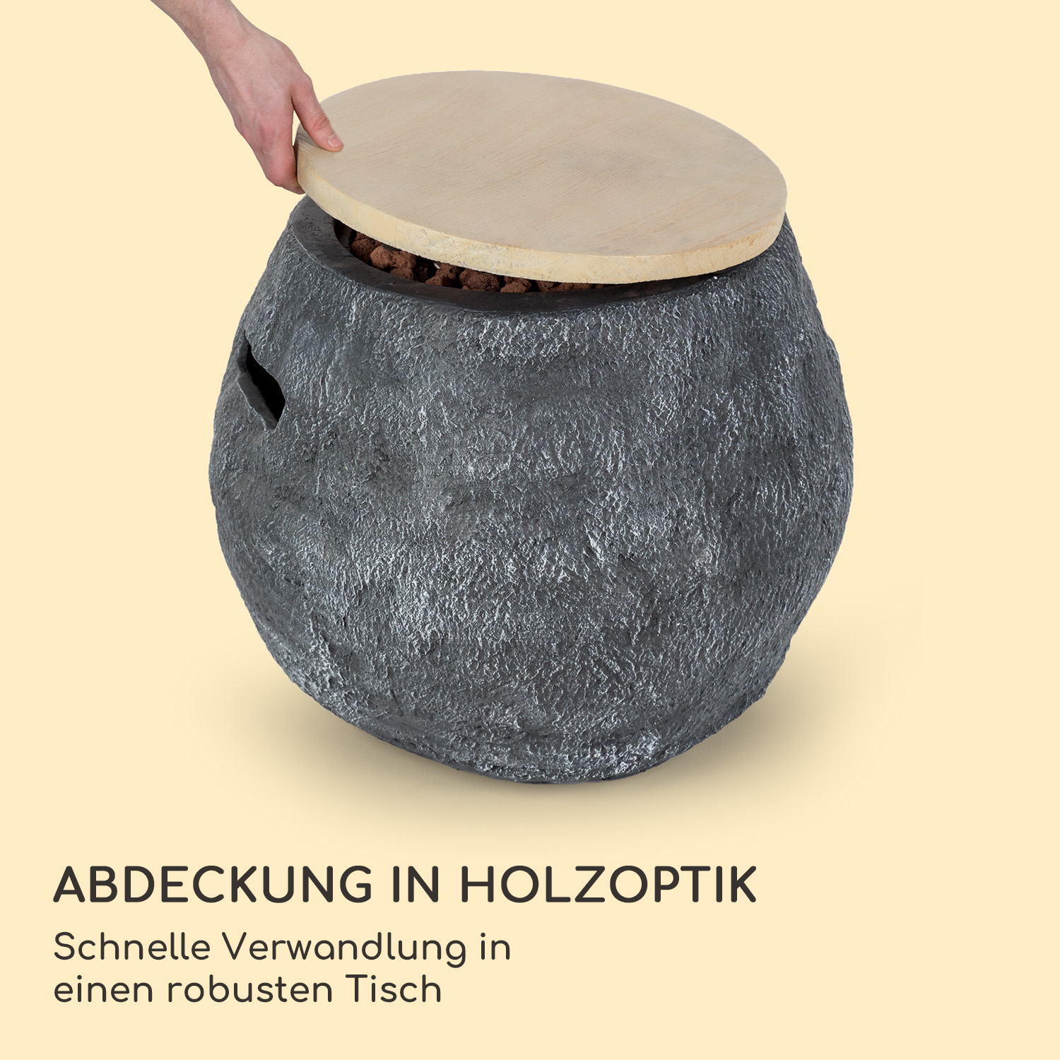 Eine Person, die einen grauen, steinartigen Aufbewahrungsbehälter mit einem Holzdeckel öffnet.