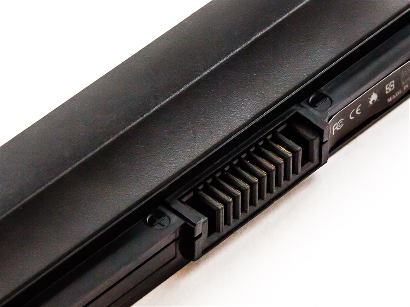 Nahaufnahme eines schwarzen Laptop-Akkus mit sichtbaren Steckerstiften. Der Akku liegt auf weißem Untergrund.