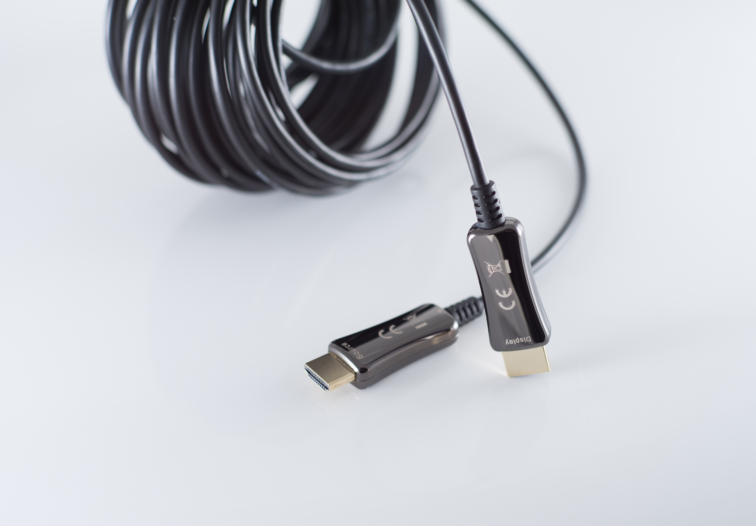 Schwarzes Kabel mit Anschlüssen an beiden Enden. Ein Anschluss hat eine metallische Oberfläche, der andere ist schwarz.