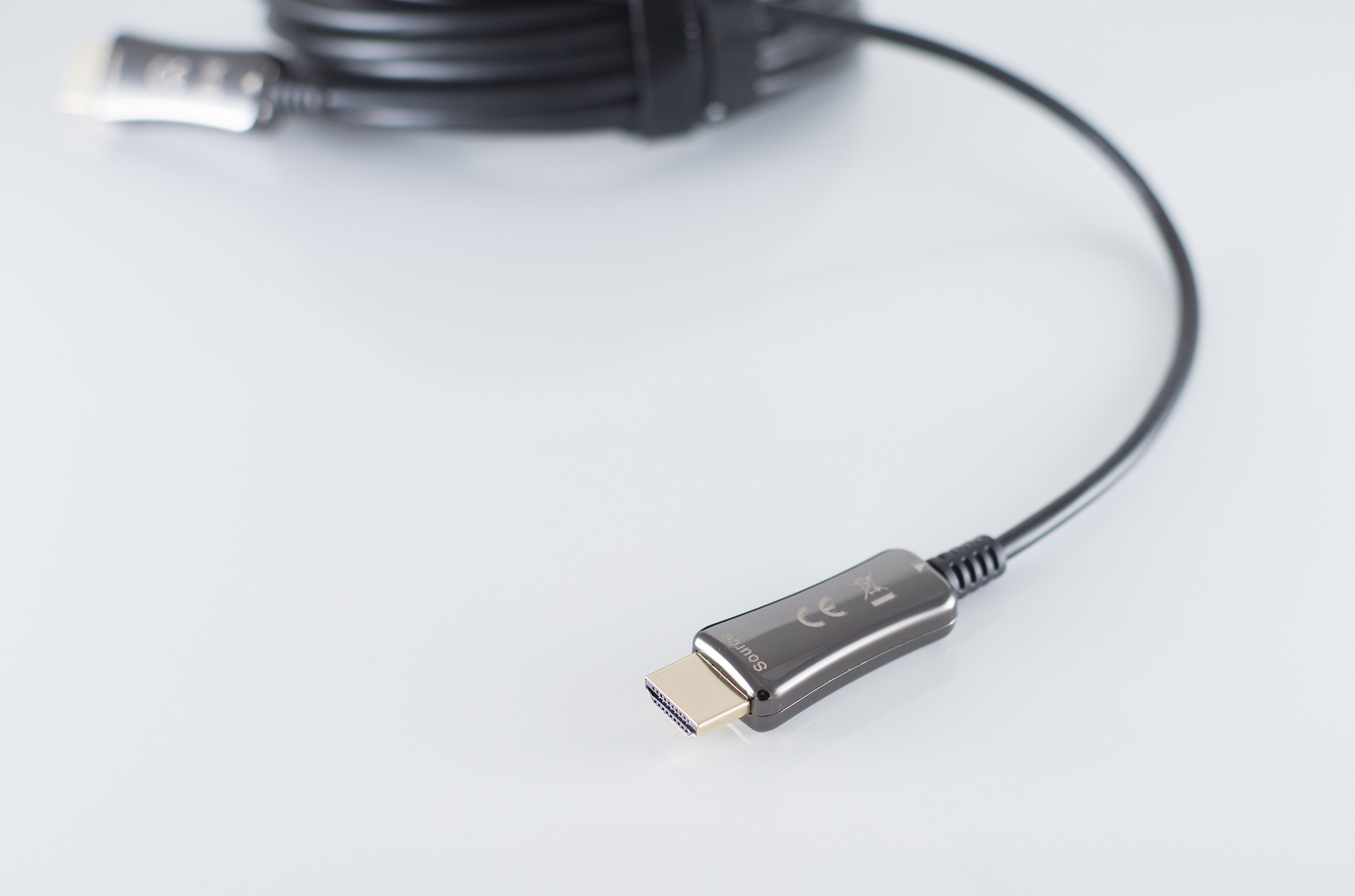 HDMI-Kabel mit Anschlüssen an jedem Ende. Ein Ende ist eingesteckt. Weißer Hintergrund.