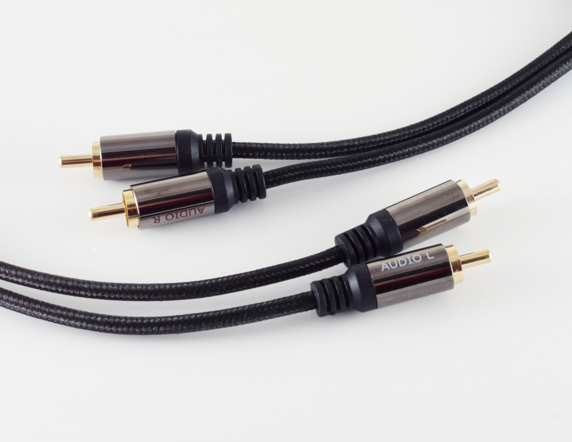 Zwei Audiokabel mit vergoldeten Steckern. Die Kabel haben eine schwarze geflochtene Ummantelung. Weißer Hintergrund.