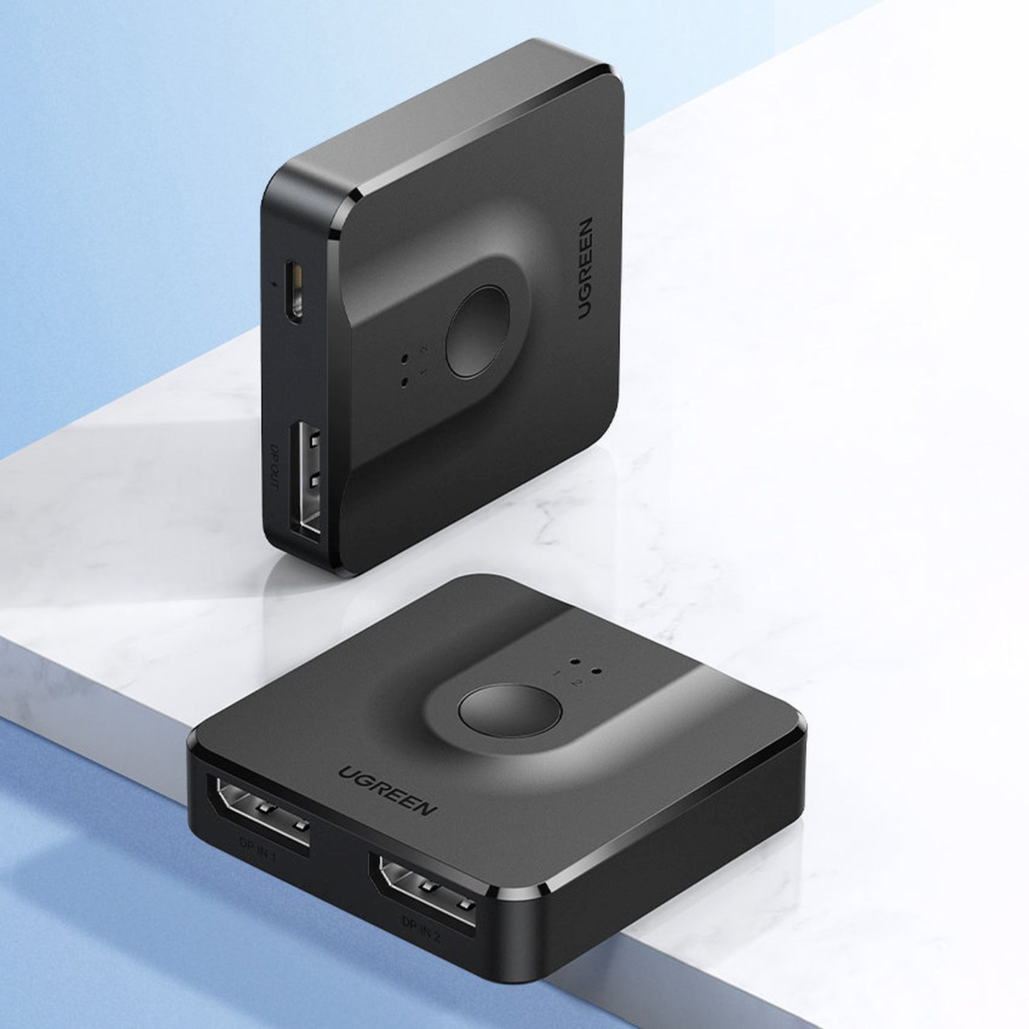 Zwei schwarze UGREEN HDMI-Umschalter. Einer mit Anschlüssen, einer ohne Anschlüsse, auf weißer Oberfläche.