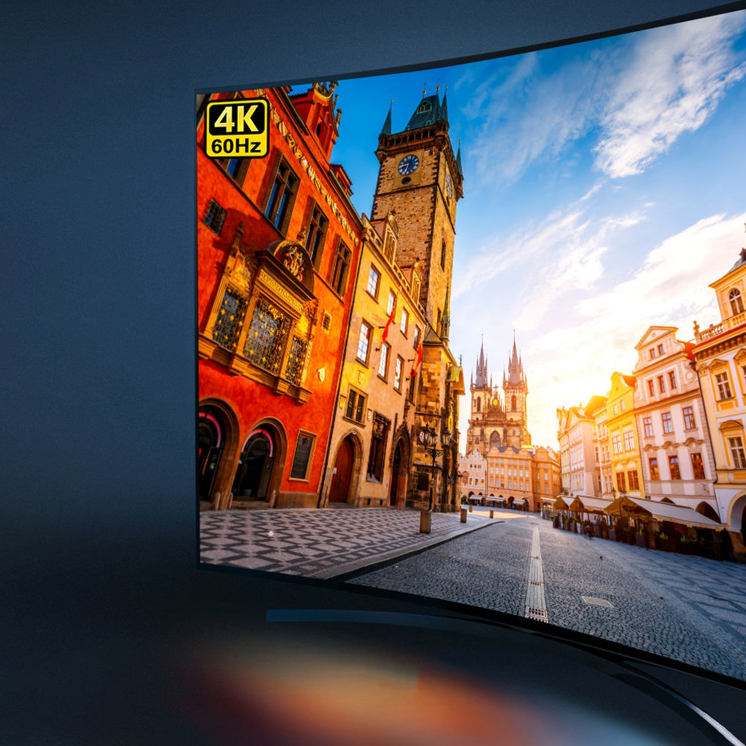 Gebogener Fernseher mit Stadtansicht, Gebäuden und blauem Himmel. Der Fernseher steht vor dunklem Hintergrund. 4K 60Hz.