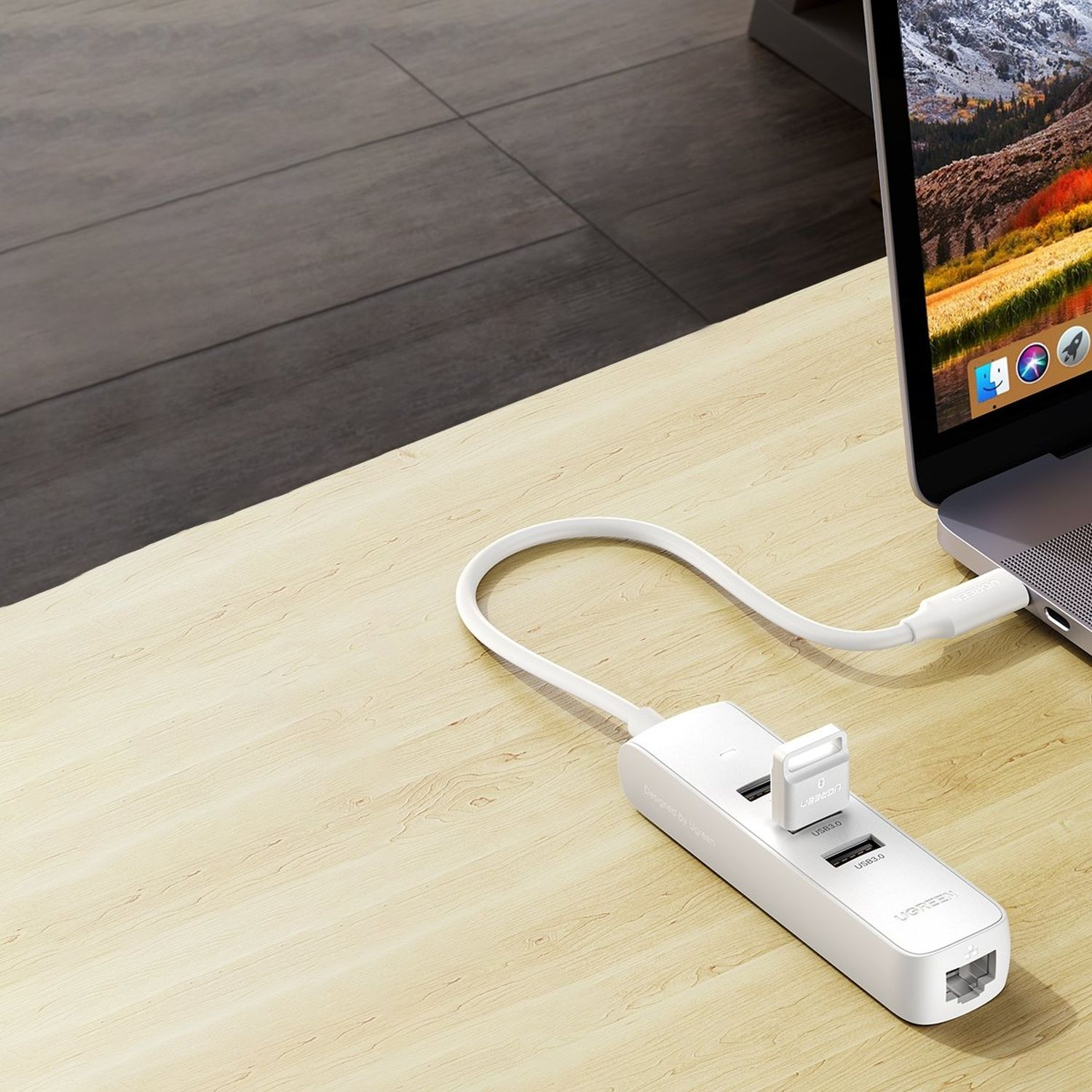 Weißer USB-Hub, der an einen Laptop angeschlossen ist. Der Hub hat mehrere USB-Anschlüsse und einen RJ45-Anschluss. Holzschreibtisch.