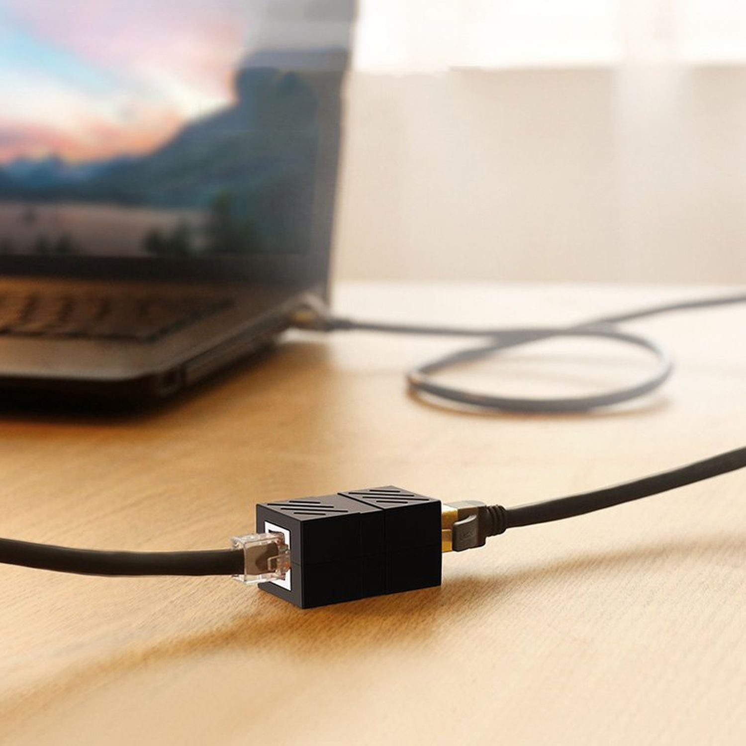 Schwarzes Netzwerkkabel, das mit einem Laptop und einem schwarzen Adapter verbunden ist.