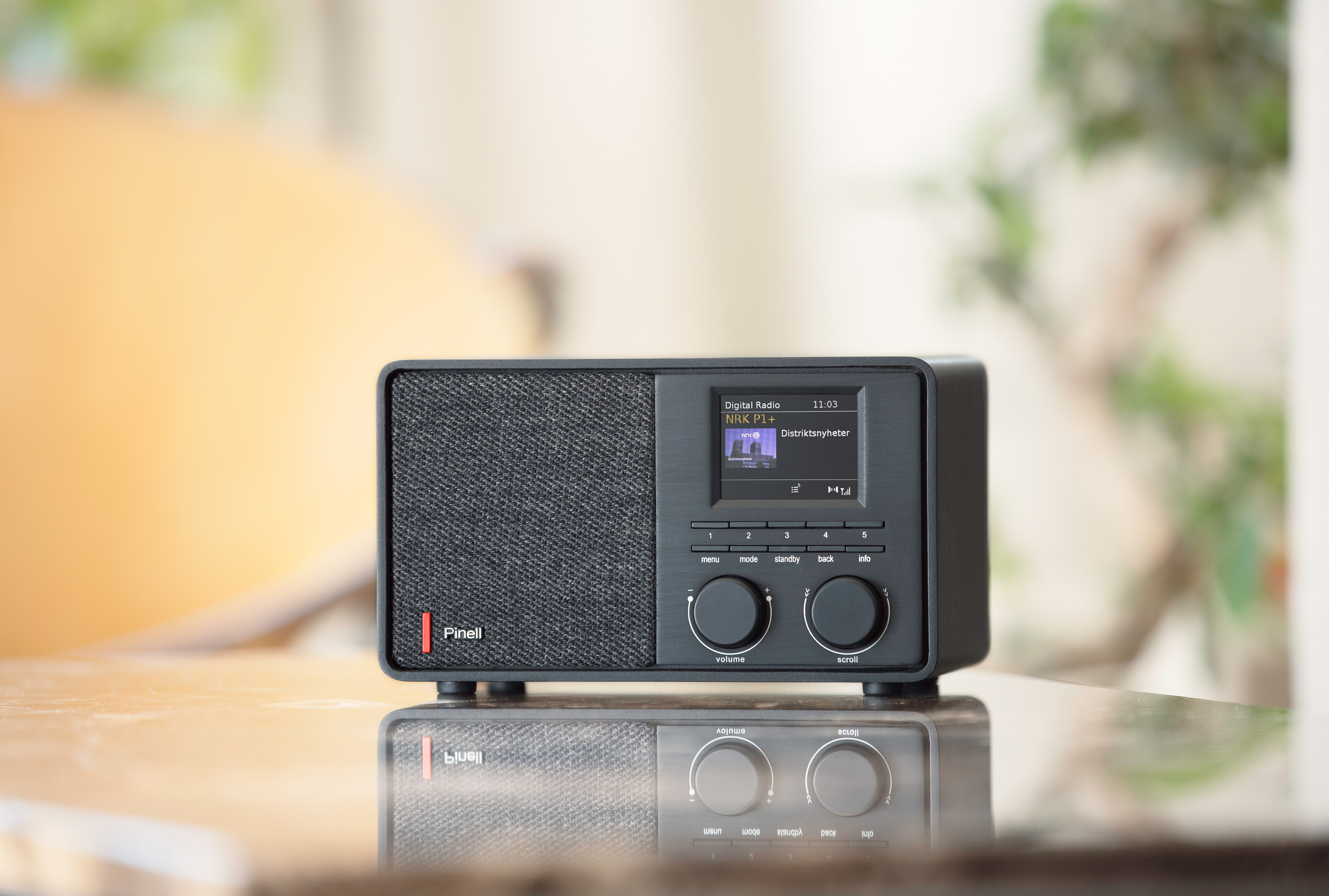 Una radio digitale nera con uno schermo che mostra informazioni. Ci sono due manopole e un altoparlante.