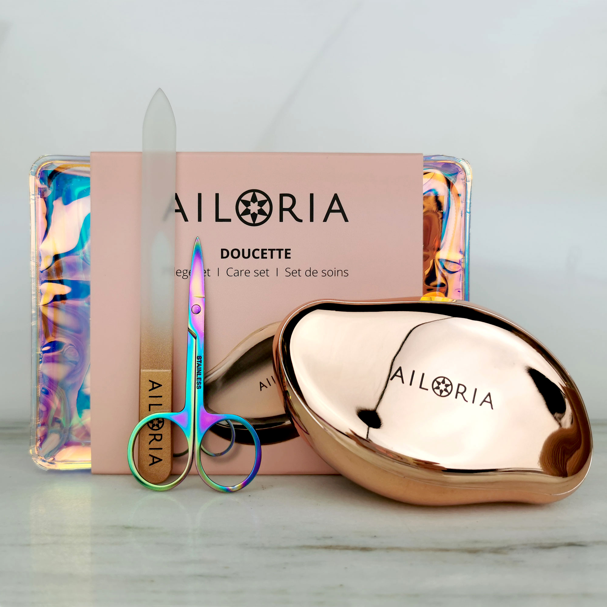 Nagelpflegeset mit Schere, Glasfeile und goldfarbenem Etui. Die Verpackung ist sichtbar.