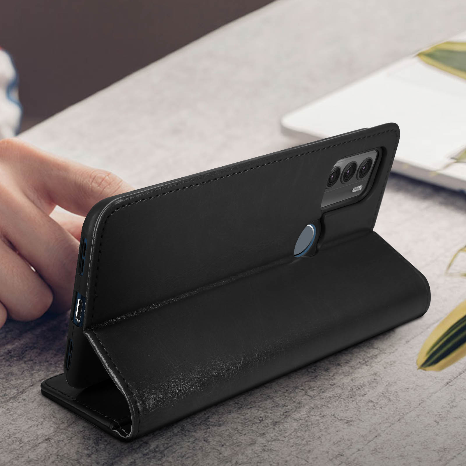 Geöffnete schwarze Handyhülle, mit Telefon darin, auf einem Holztisch.