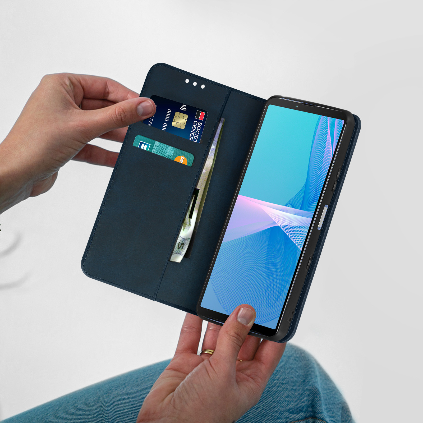 Mani che tengono una custodia per telefono, mostrando un telefono con carte e contanti all'interno.