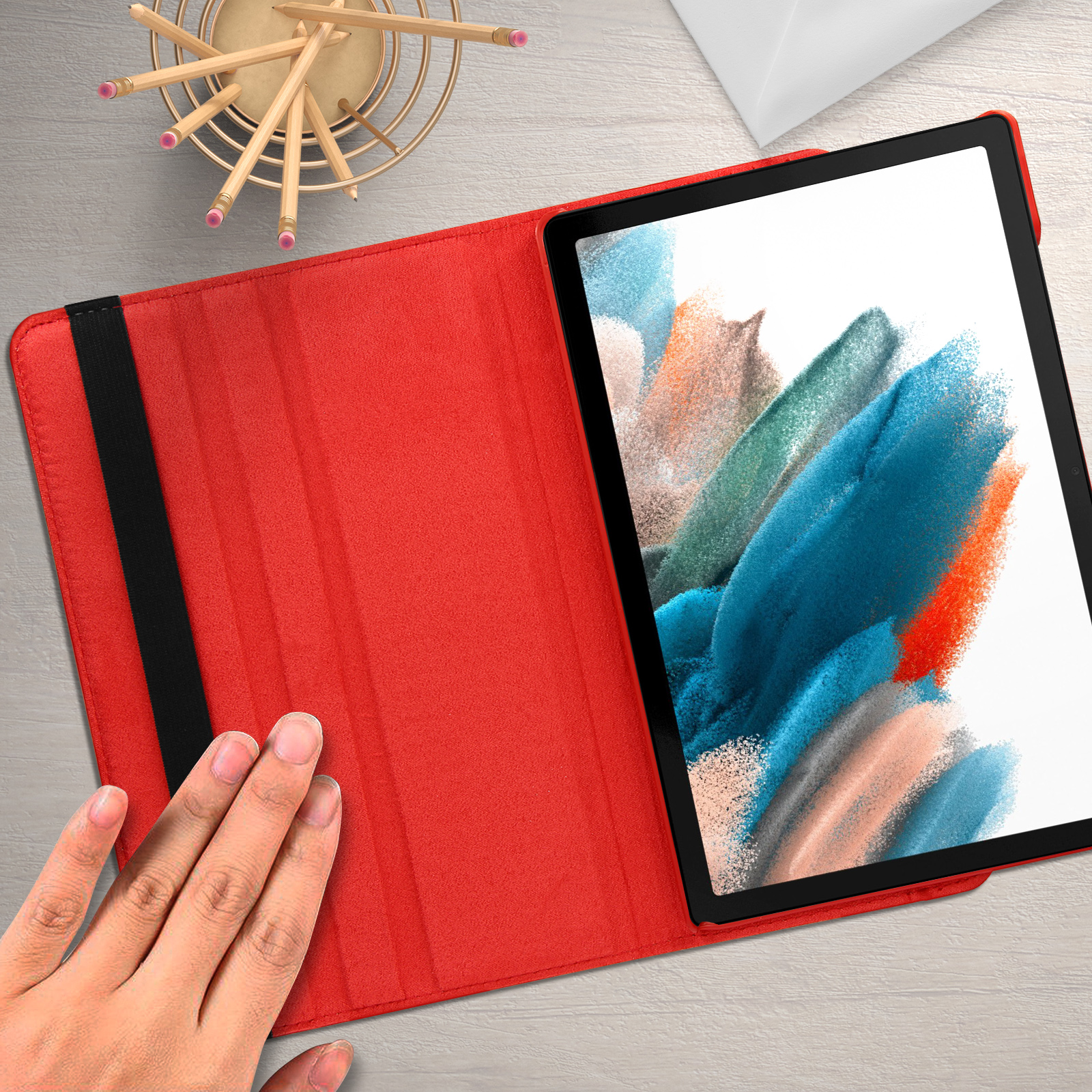 Custodia per tablet rossa aperta con un tablet all'interno. La mano tocca la custodia.