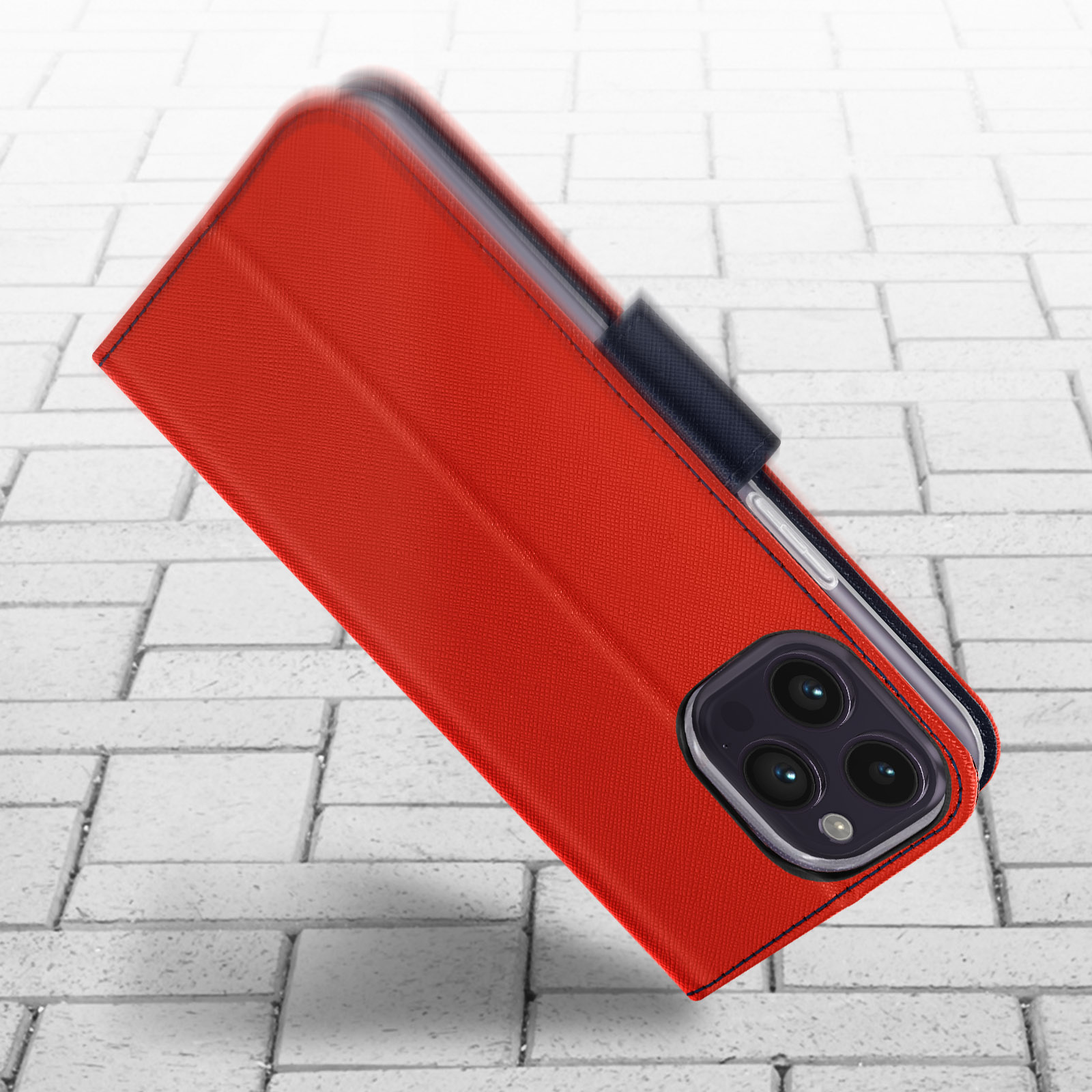 Una custodia rossa con chiusura nera appoggiata su una superficie di mattoni, mostra un telefono.