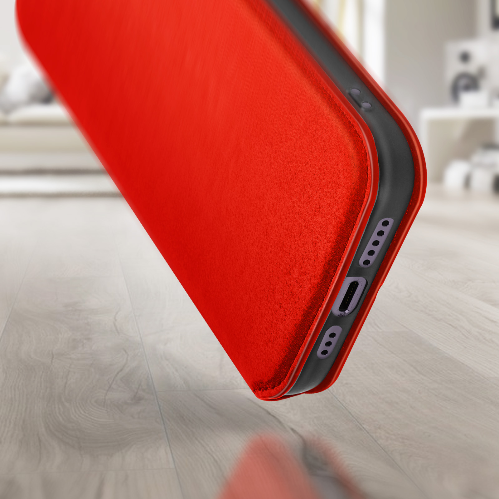 Coque de téléphone rouge inclinée sur un sol en bois. Ports et boutons visibles sur le côté.