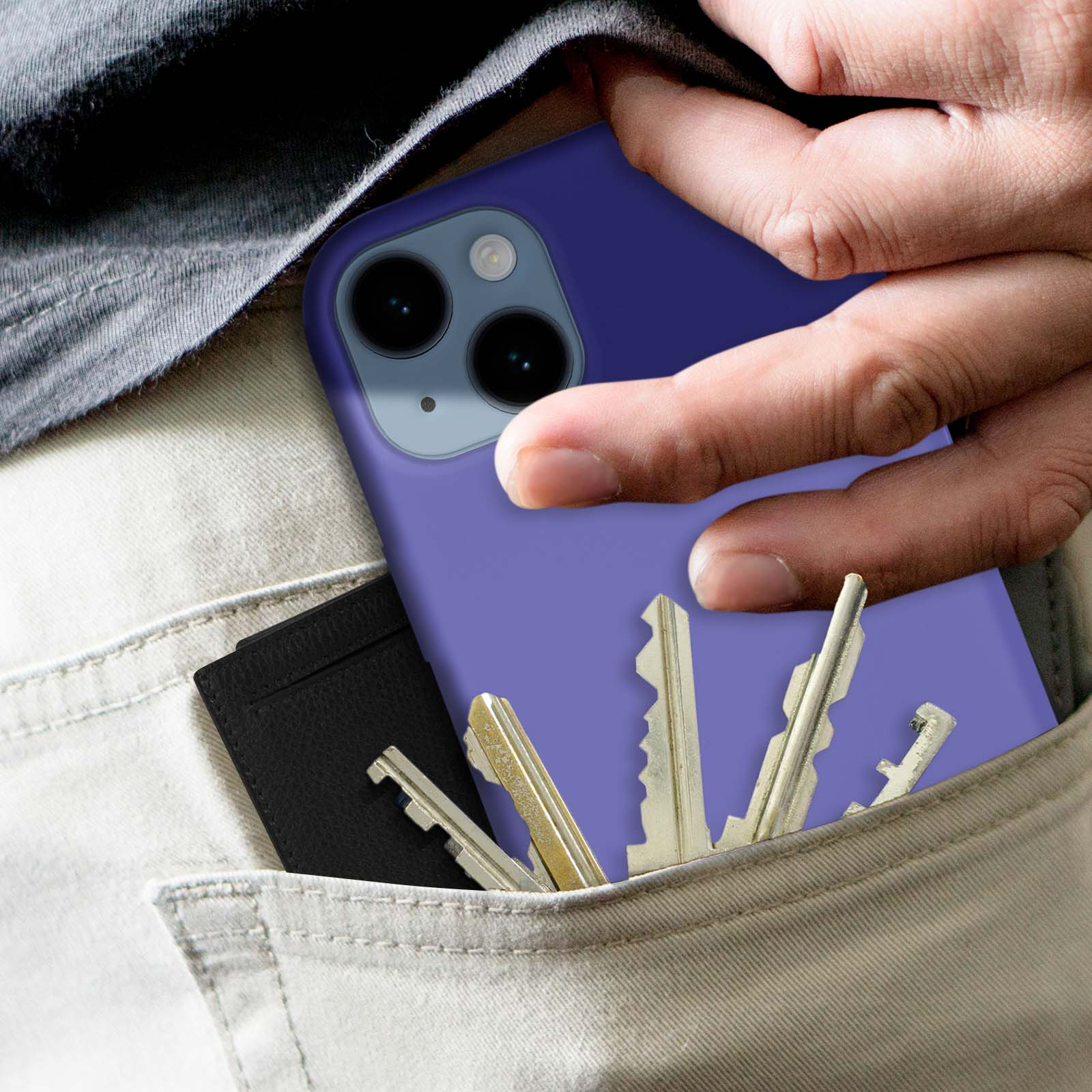 Een hand in een zak met een telefoon en sleutels. Een zwarte portemonnee is zichtbaar.
