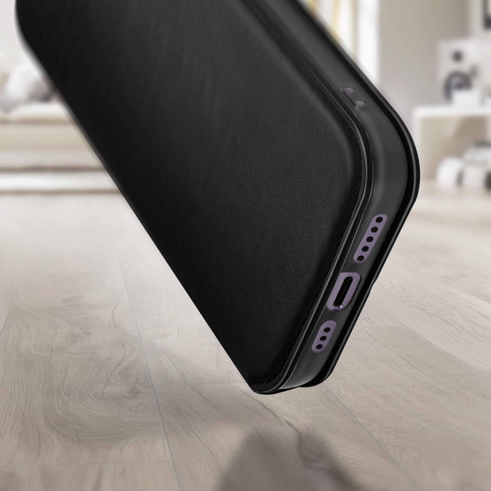 Un étui noir est sur une surface en bois. Quelques détails sont visibles sur le bord.