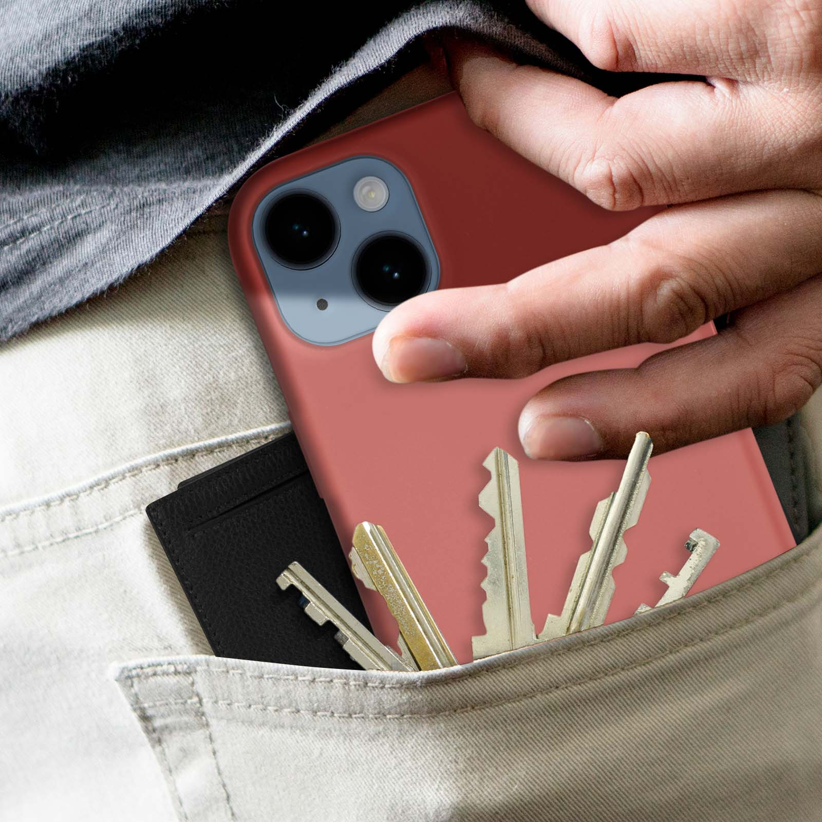 Hand die een rode telefoon vasthoudt, sleutels in de zak. Zwarte portemonnee in de zak.