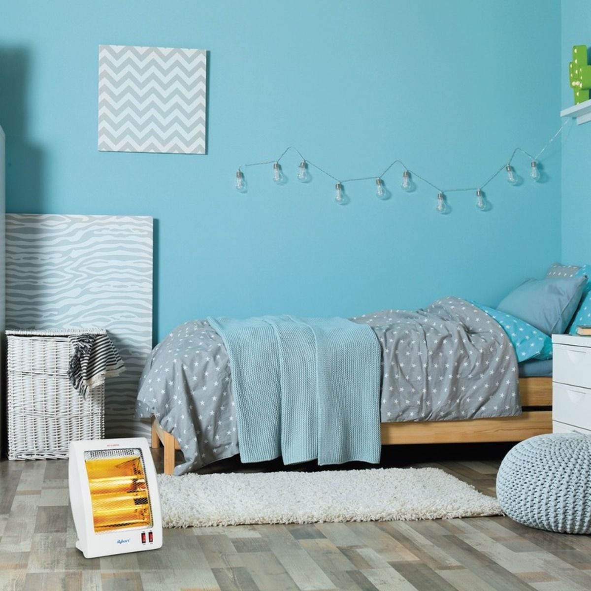 Escena de dormitorio con cama, calefactor, arte y luces de cadena en pared azul.