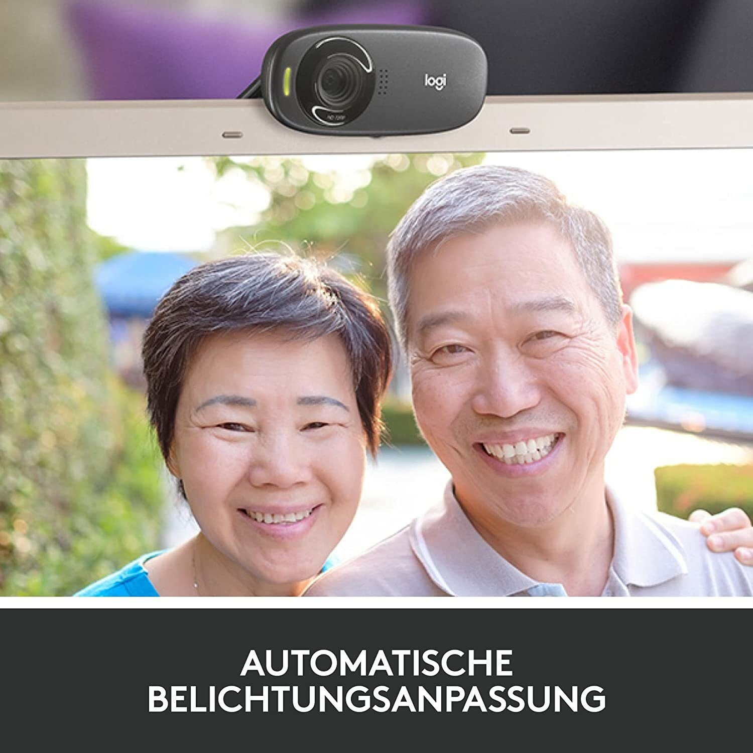 Eine Webcam, die auf einem Computerbildschirm montiert ist und ein lächelndes älteres Ehepaar zeigt.