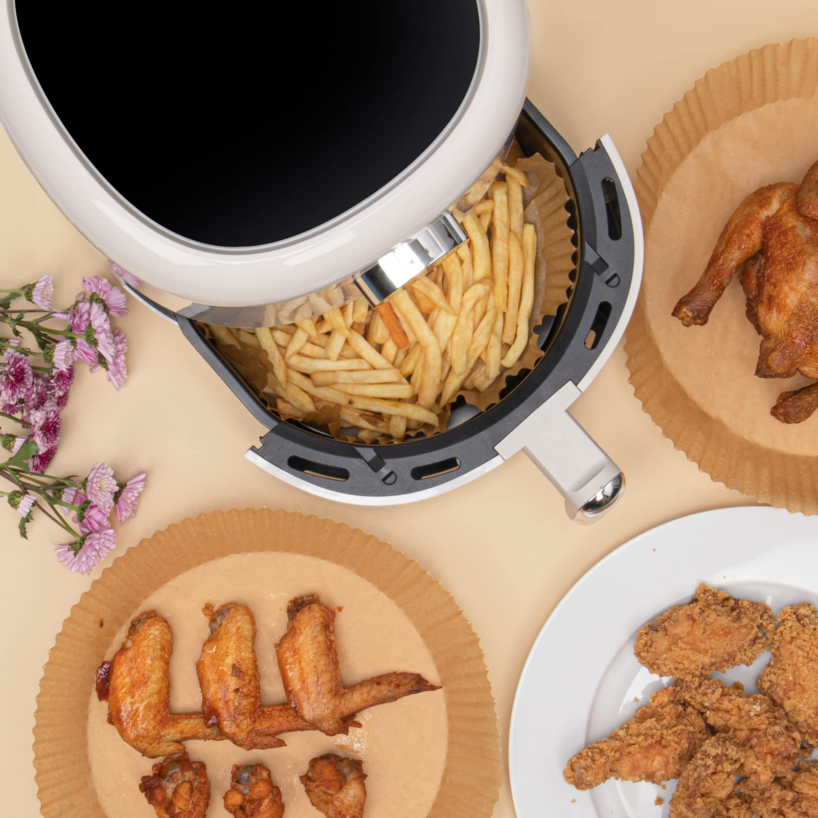 Eine Heißluftfritteuse mit Pommes Frites und anderen frittierten Speisen wie Flügeln und ganzem Huhn.
