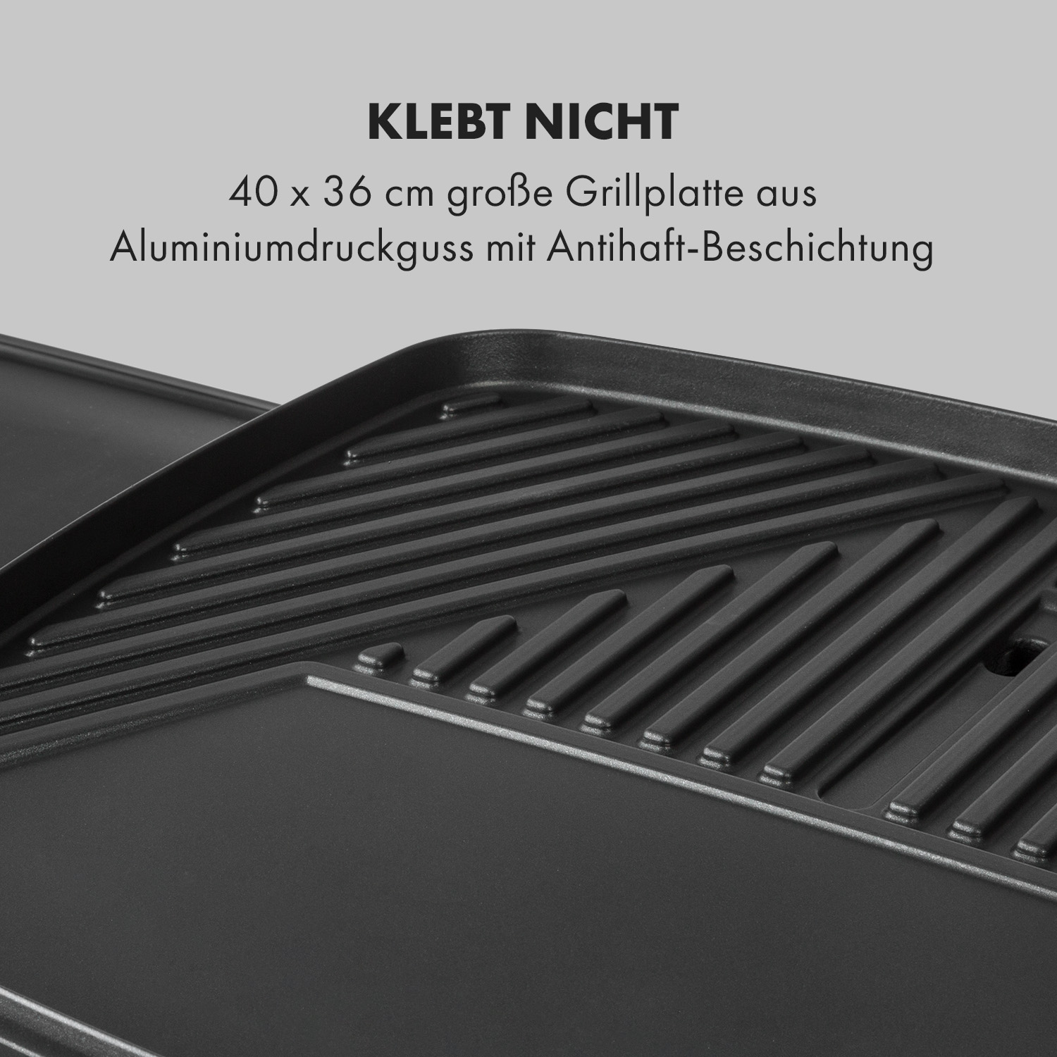 Nahaufnahme einer schwarzen Grillplatte. Es ist eine antihaftbeschichtete Grillfläche aus Aluminiumdruckguss mit Rillen.