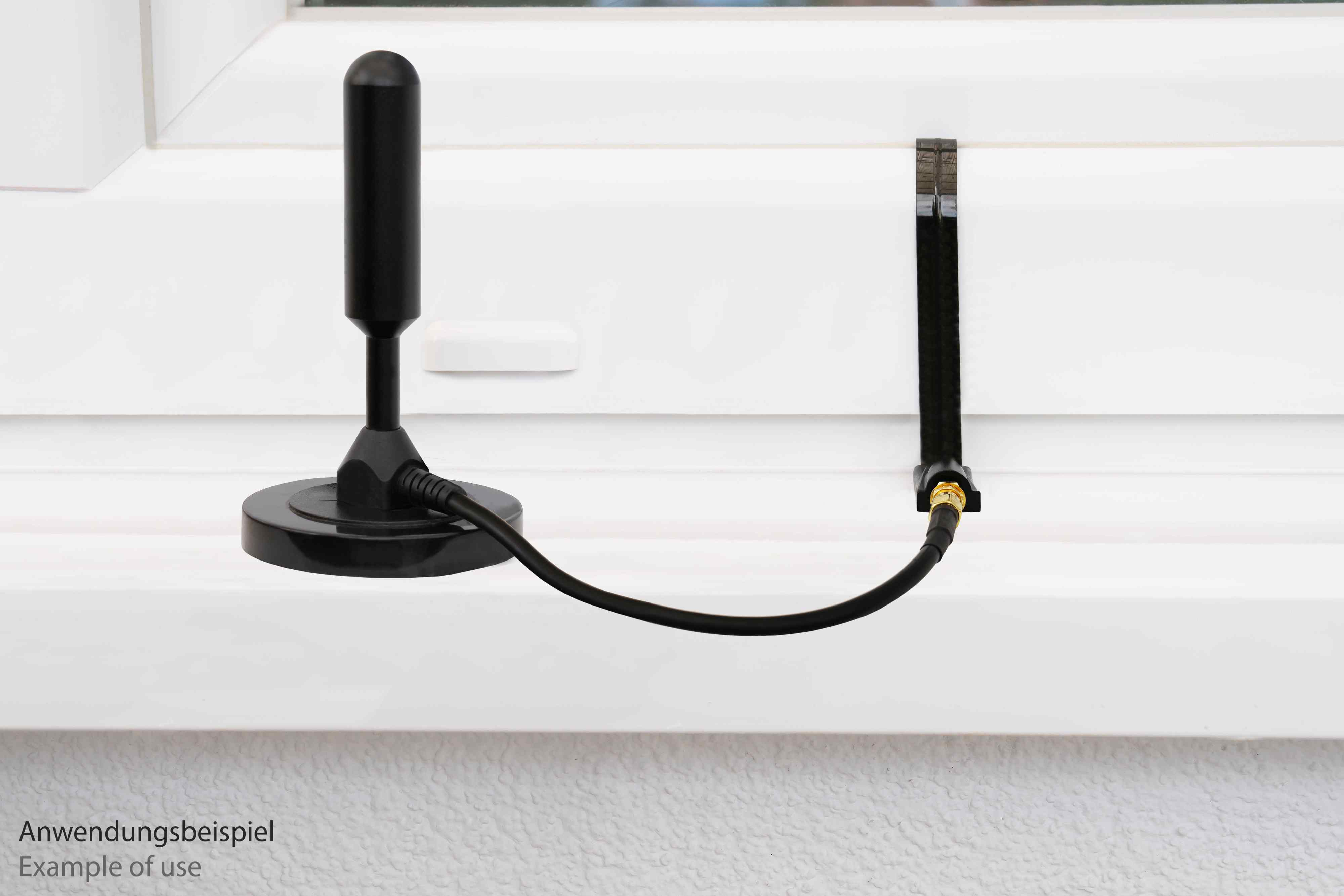 Schwarze Fensterantenne, verbunden mit schwarzem Kabel. Anwendungsbeispiel.