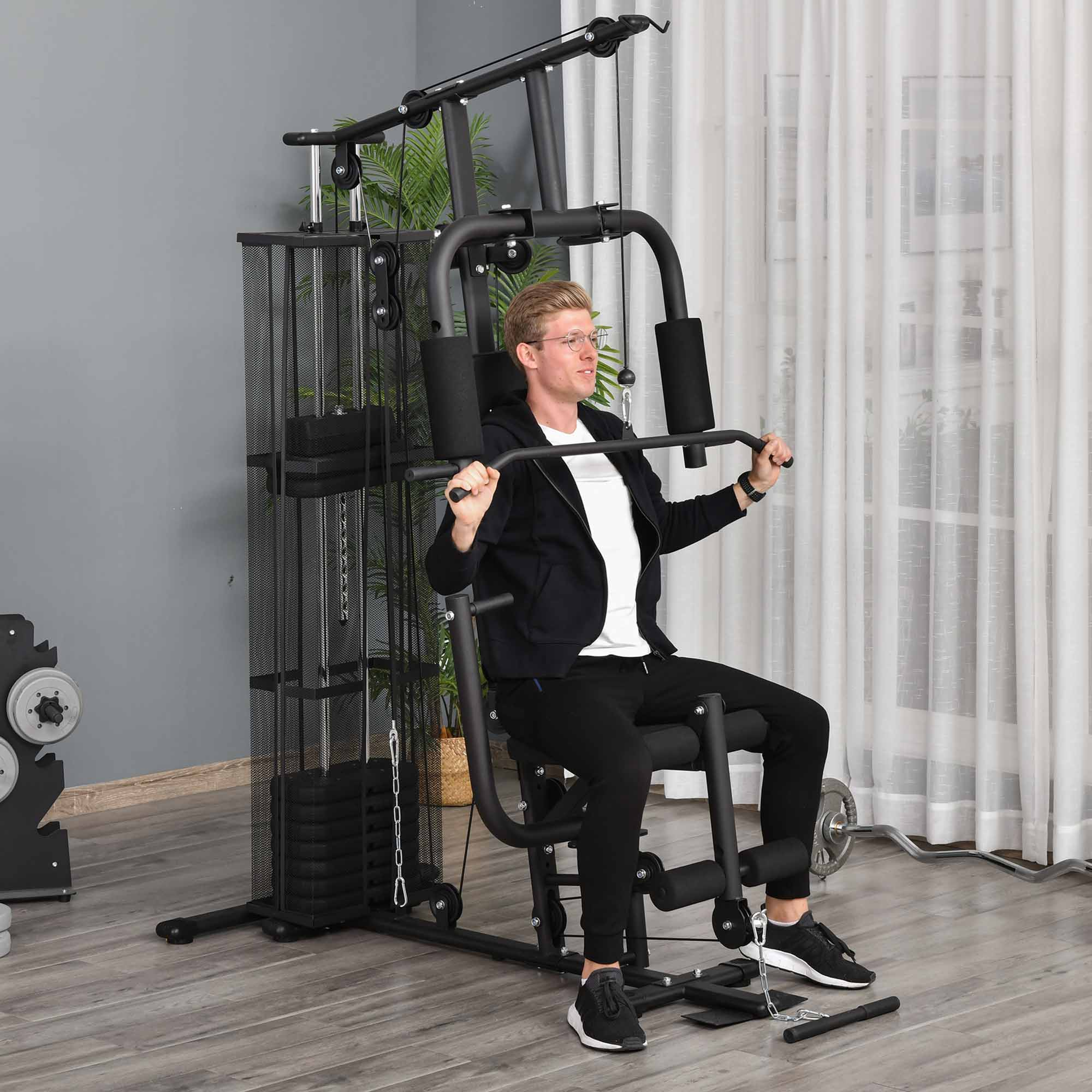 Hombre usando máquina de gimnasio en casa negra y gris en un ambiente doméstico.