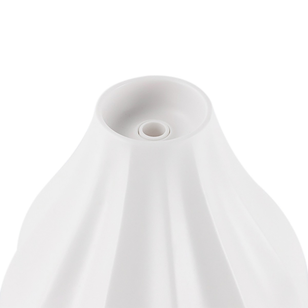 Primo piano di un diffusore in ceramica bianca e scanalata con un foro centrale.