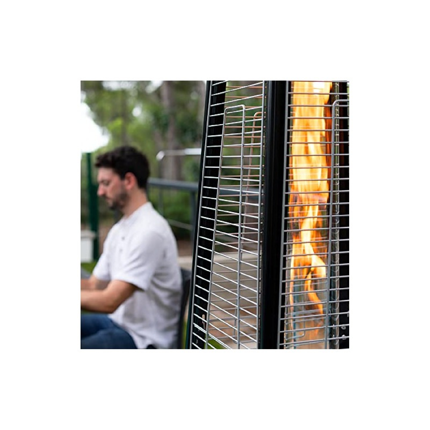 Ein Gas-Terrassenheizer mit Flammen hinter einem Metallgitter. Im Hintergrund ist ein Mann verschwommen.