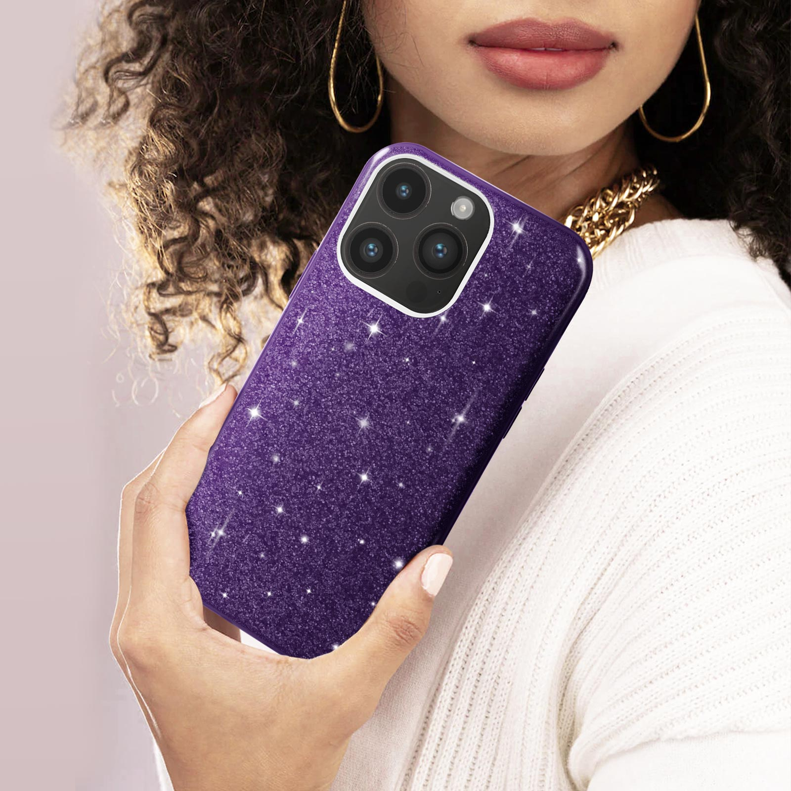 Donna che tiene una custodia glitterata viola con fotocamera a tripla lente.
