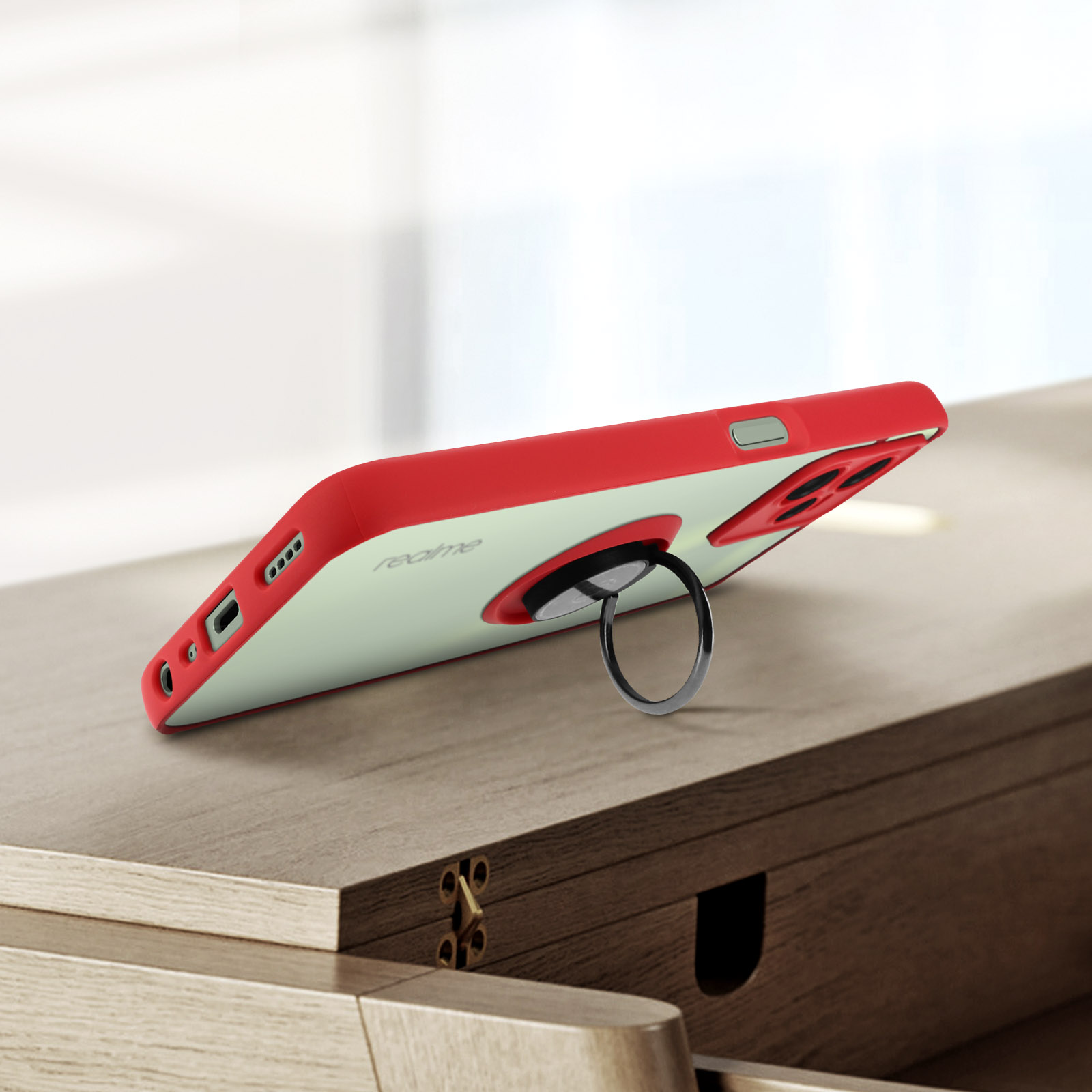 Una custodia per telefono rossa e trasparente con un supporto ad anello su una superficie di legno.
