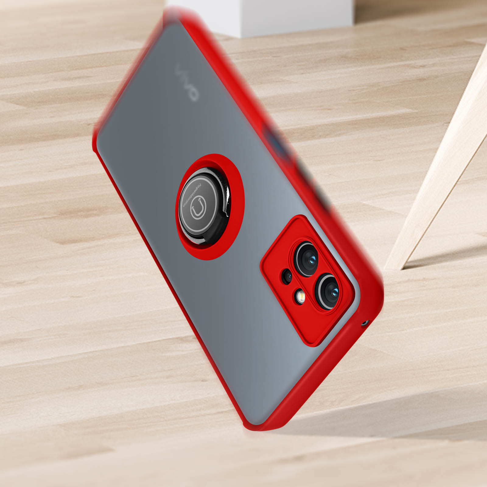 Custodia per telefono con bordo rosso con anello per fotocamera e telefono su superficie in legno.