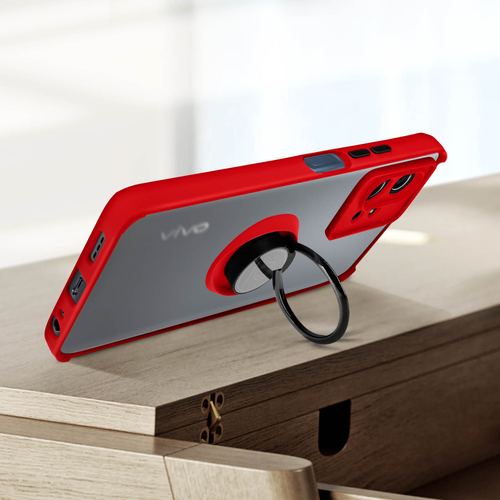 Custodia per telefono rossa e grigia con anello di supporto, posizionata su una superficie di legno.