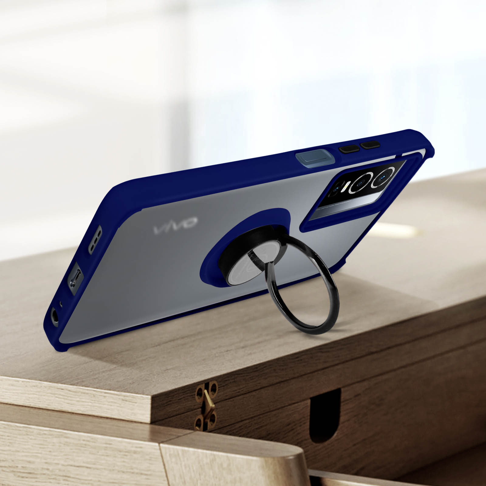 Custodia per telefono blu e grigia con un porta anello, angolata su una superficie di legno.
