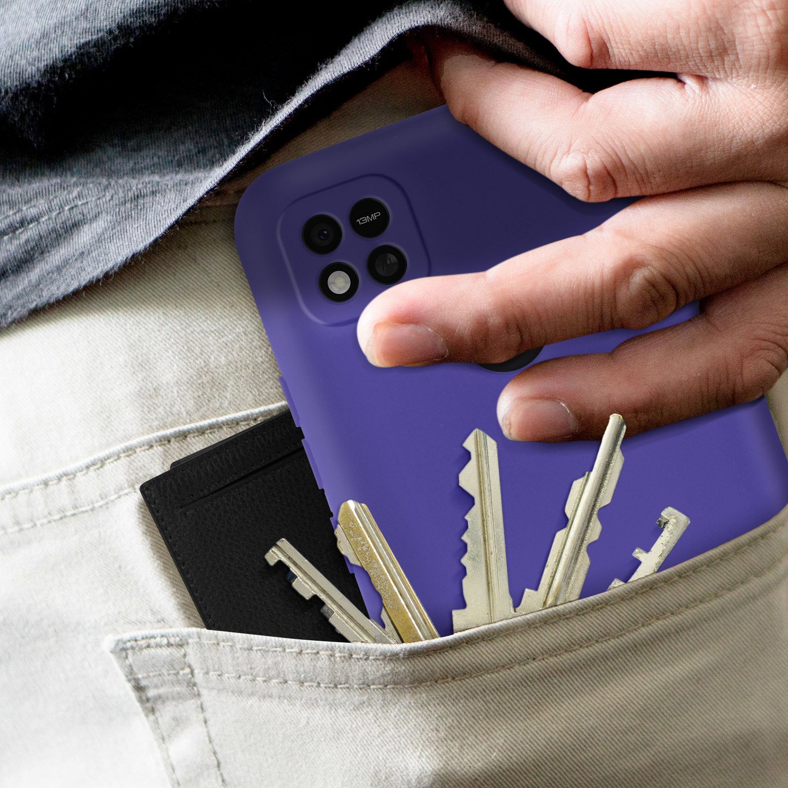 Une main tient une coque de téléphone violette avec un téléphone dedans. Des clés et une carte sont dans la poche.