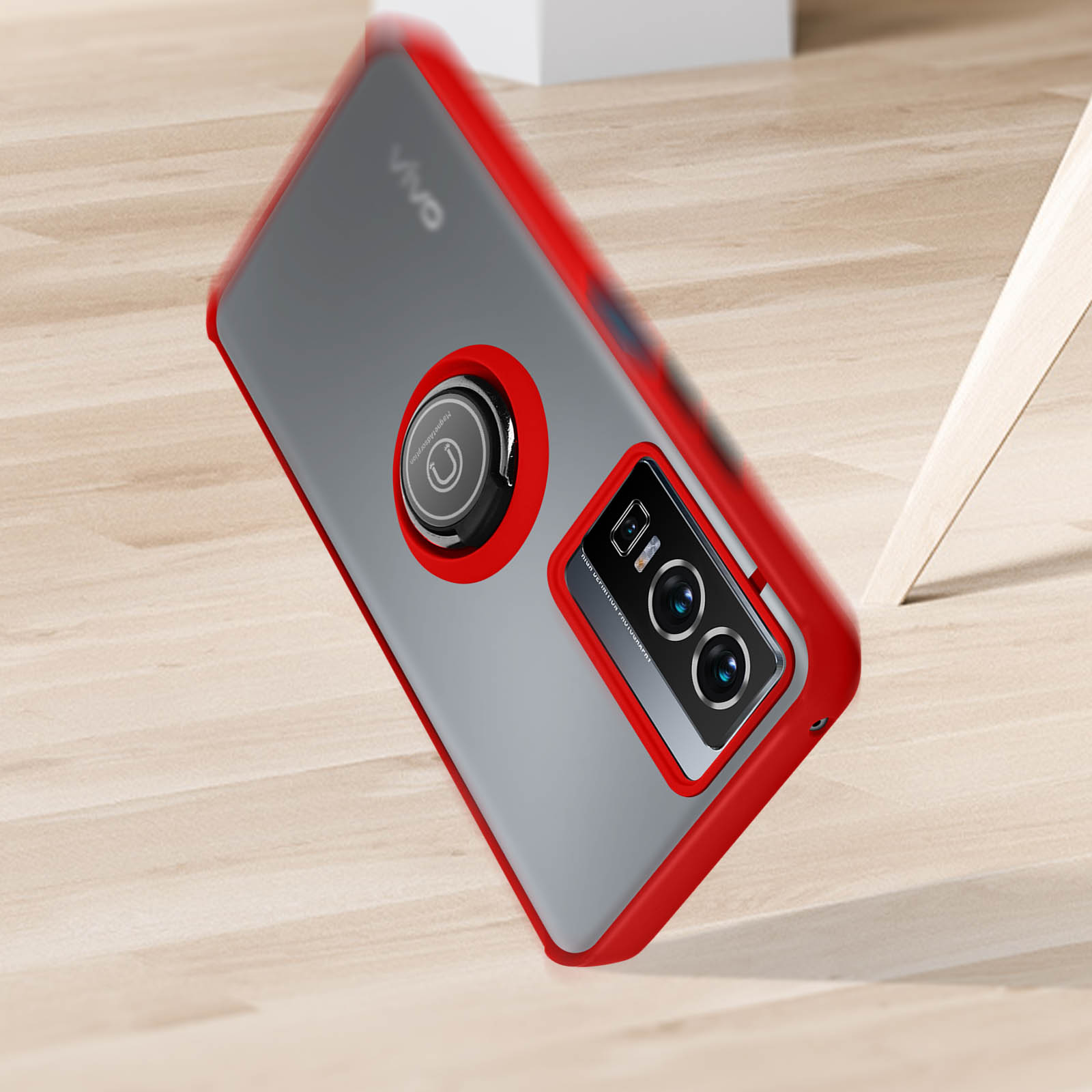 Custodia per telefono con bordo rosso e supporto ad anello su una superficie in legno.