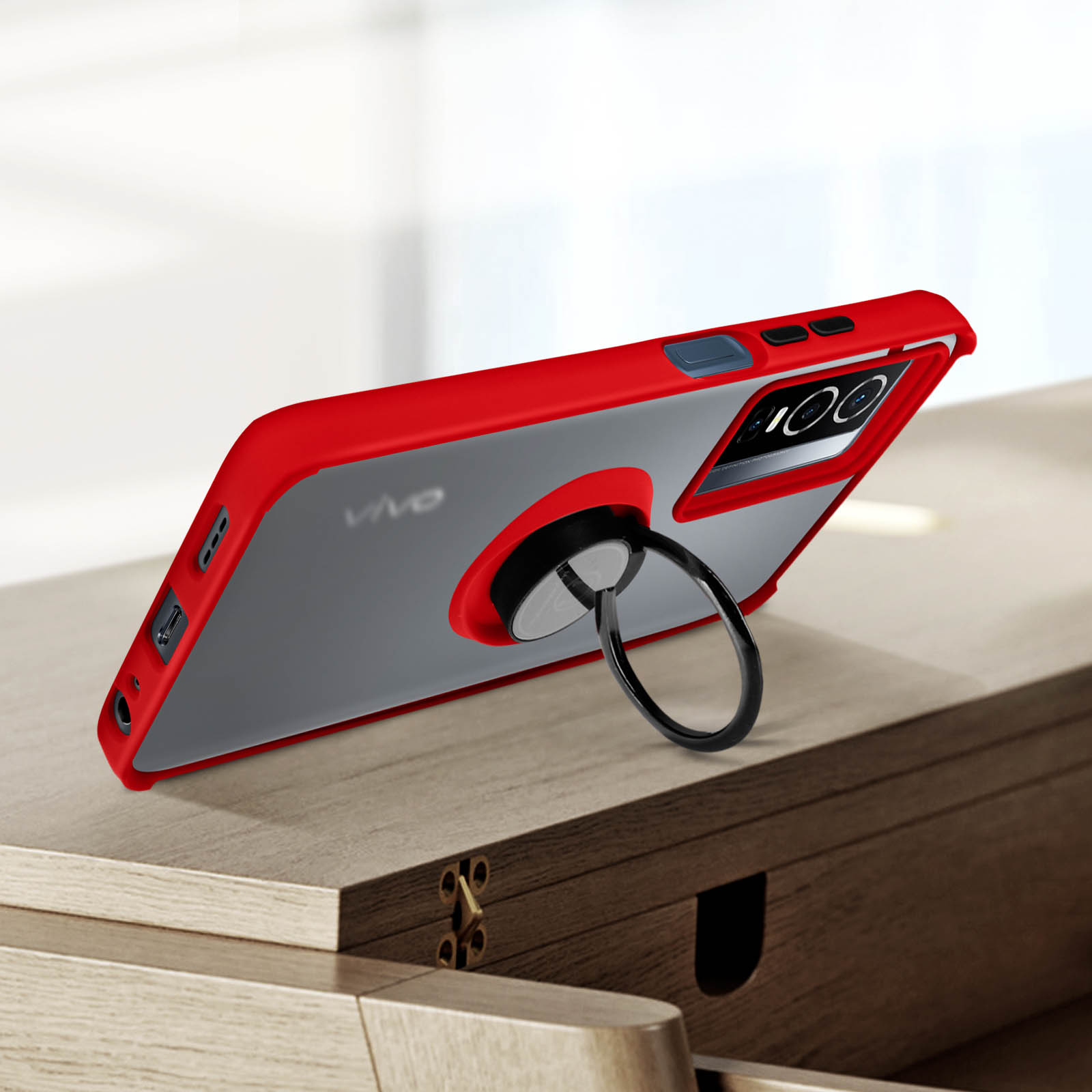 Una custodia per telefono rossa e grigia con un portanello. È su una superficie di legno.