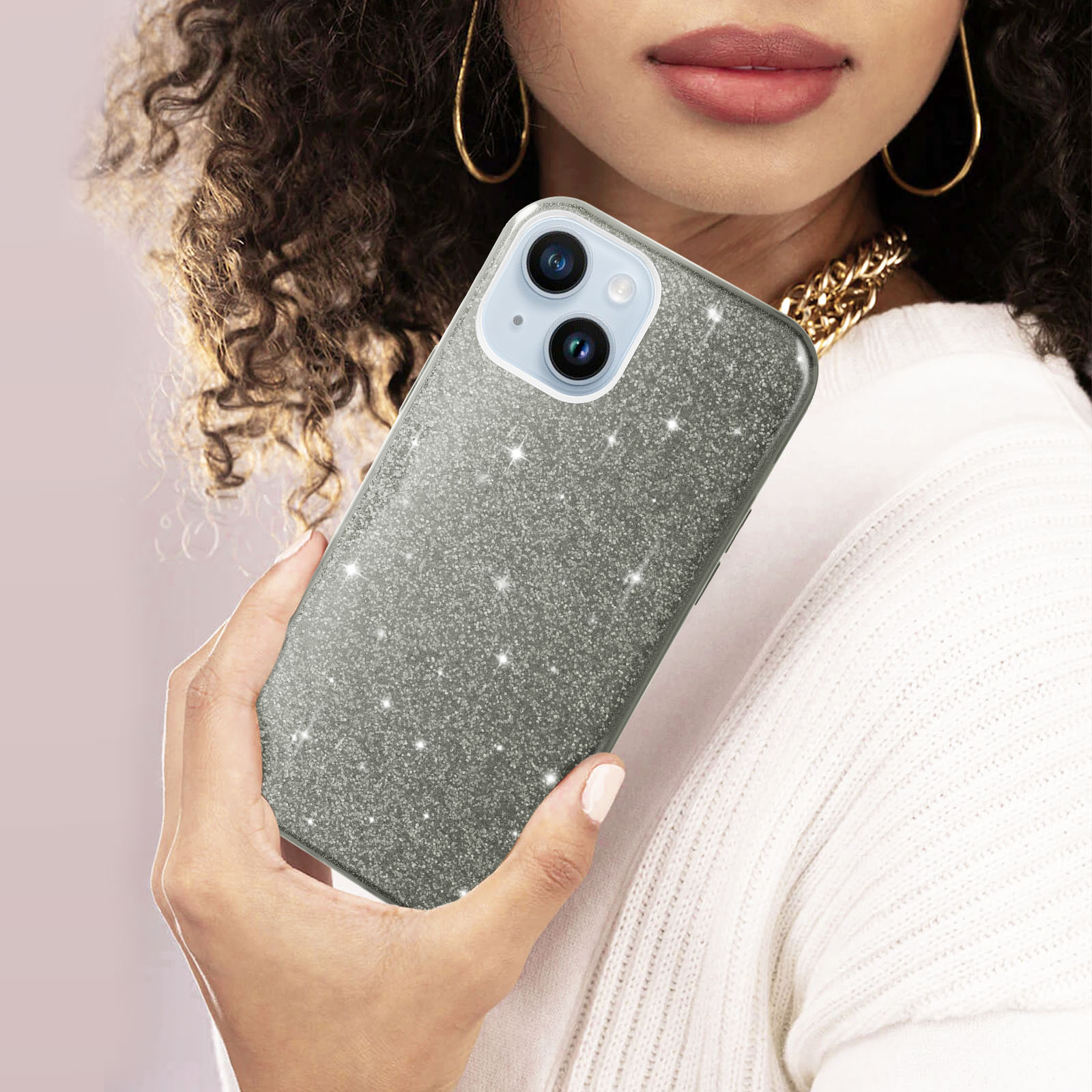 Una donna che tiene una custodia per telefono argentata. La custodia ha glitter ed è argentata.