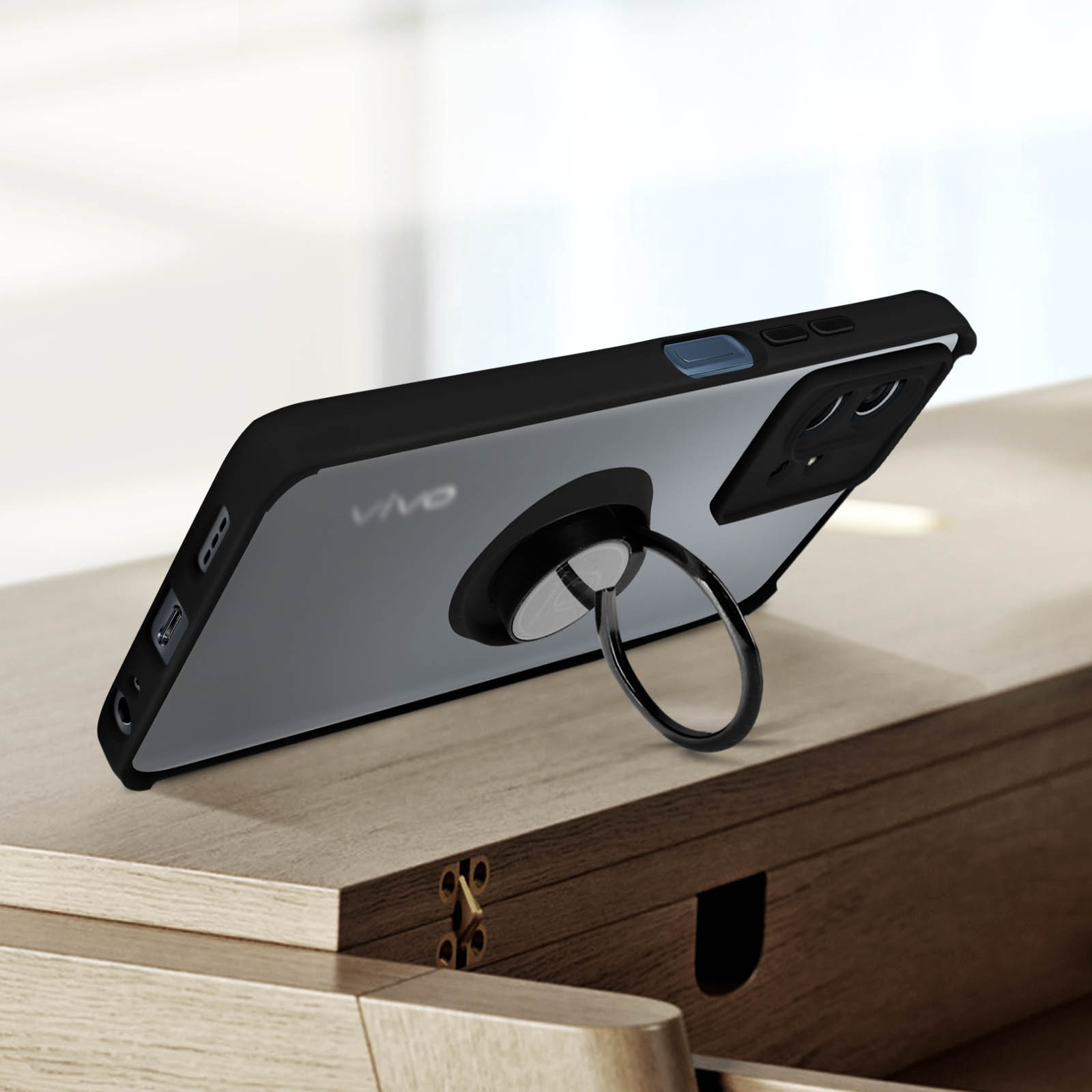 Custodia nera per telefono con supporto ad anello, su una superficie di legno.