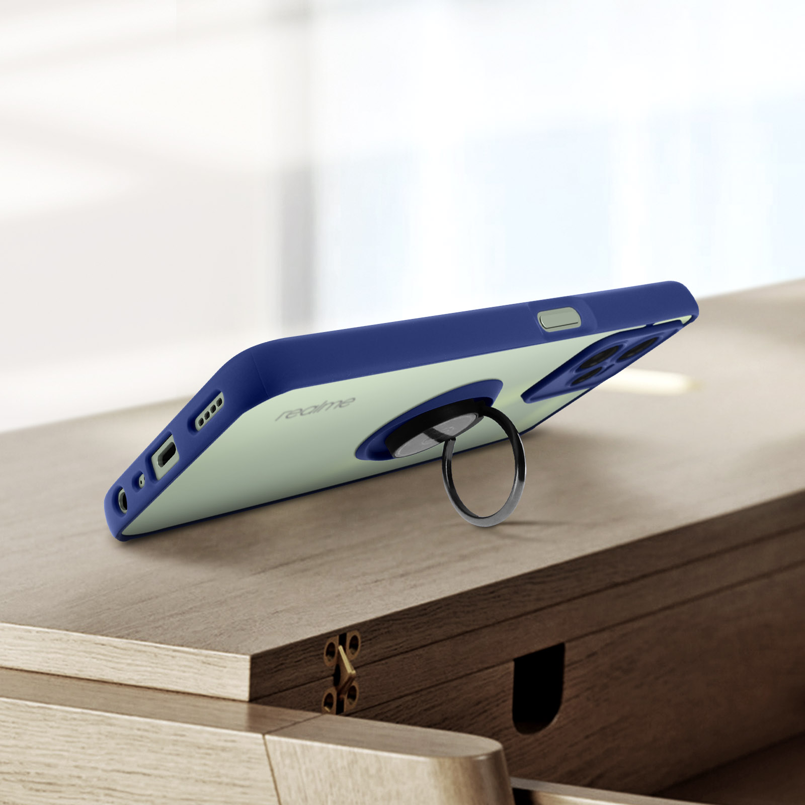 Una custodia per telefono blu navy e trasparente con un supporto ad anello, su una superficie di legno.