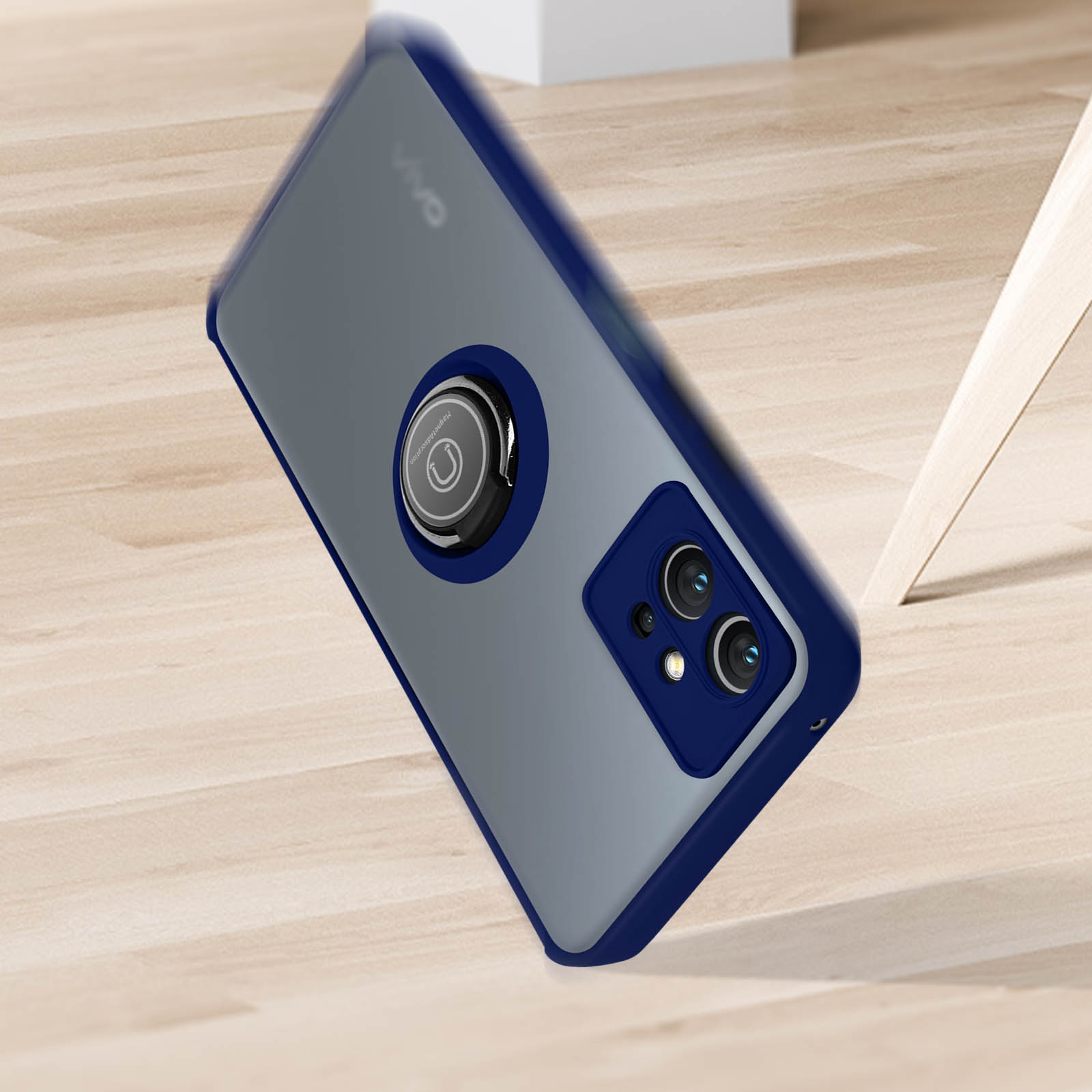 Custodia per telefono blu e grigia con supporto ad anello circolare, su superficie in legno.
