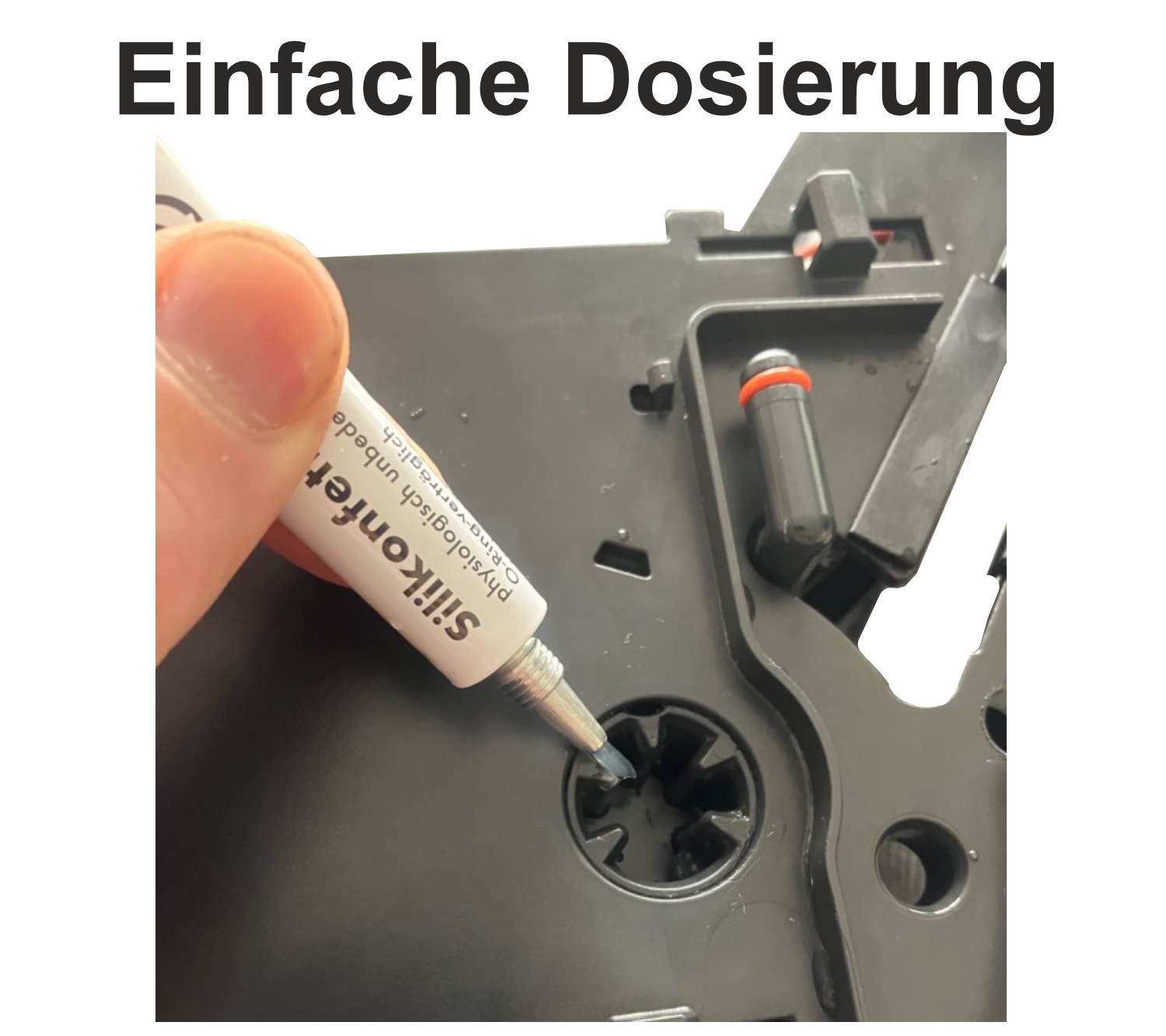 Eine Hand drückt Silikondichtmasse aus einer Tube auf eine dunkle Oberfläche.