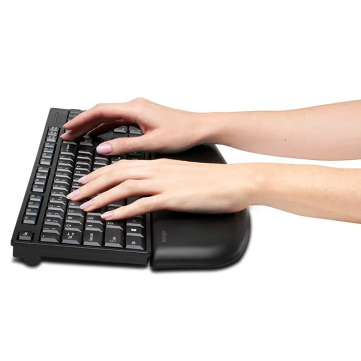 Manos tecleando en un teclado ergonómico negro con reposamuñecas.