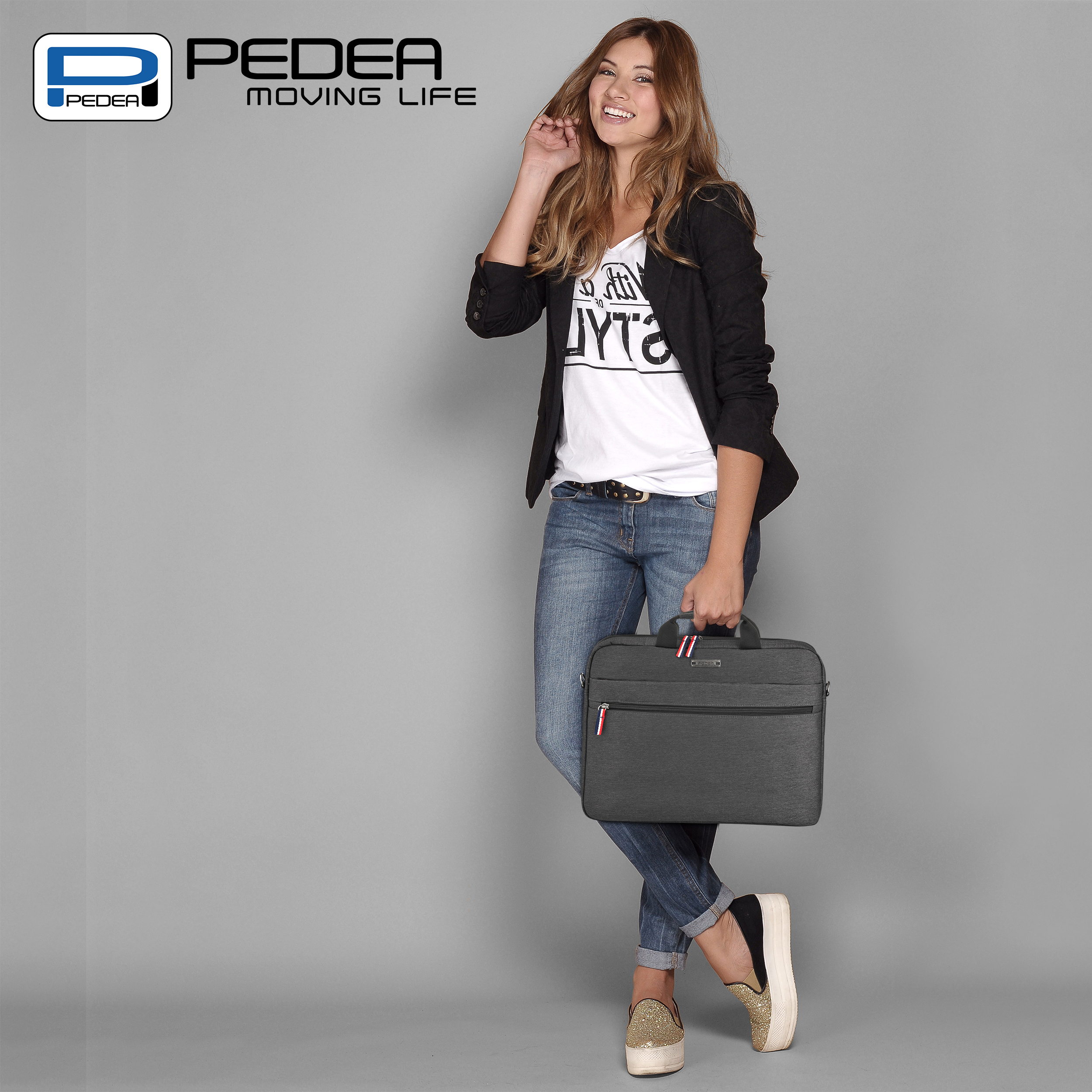 Giovane donna in jeans e blazer che tiene una ventiquattrore, sorridente, in studio.