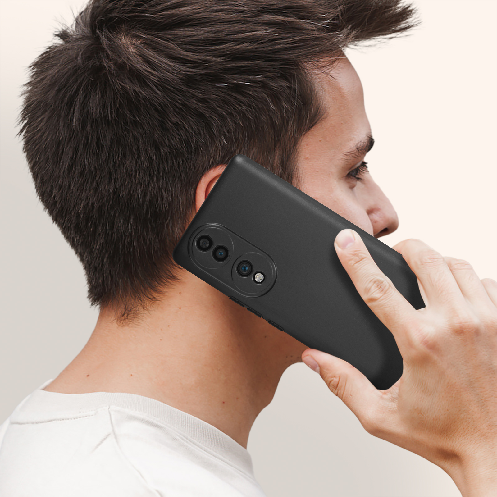 Un uomo che tiene un telefono nero all'orecchio, che parla. Il telefono ha una custodia nera.