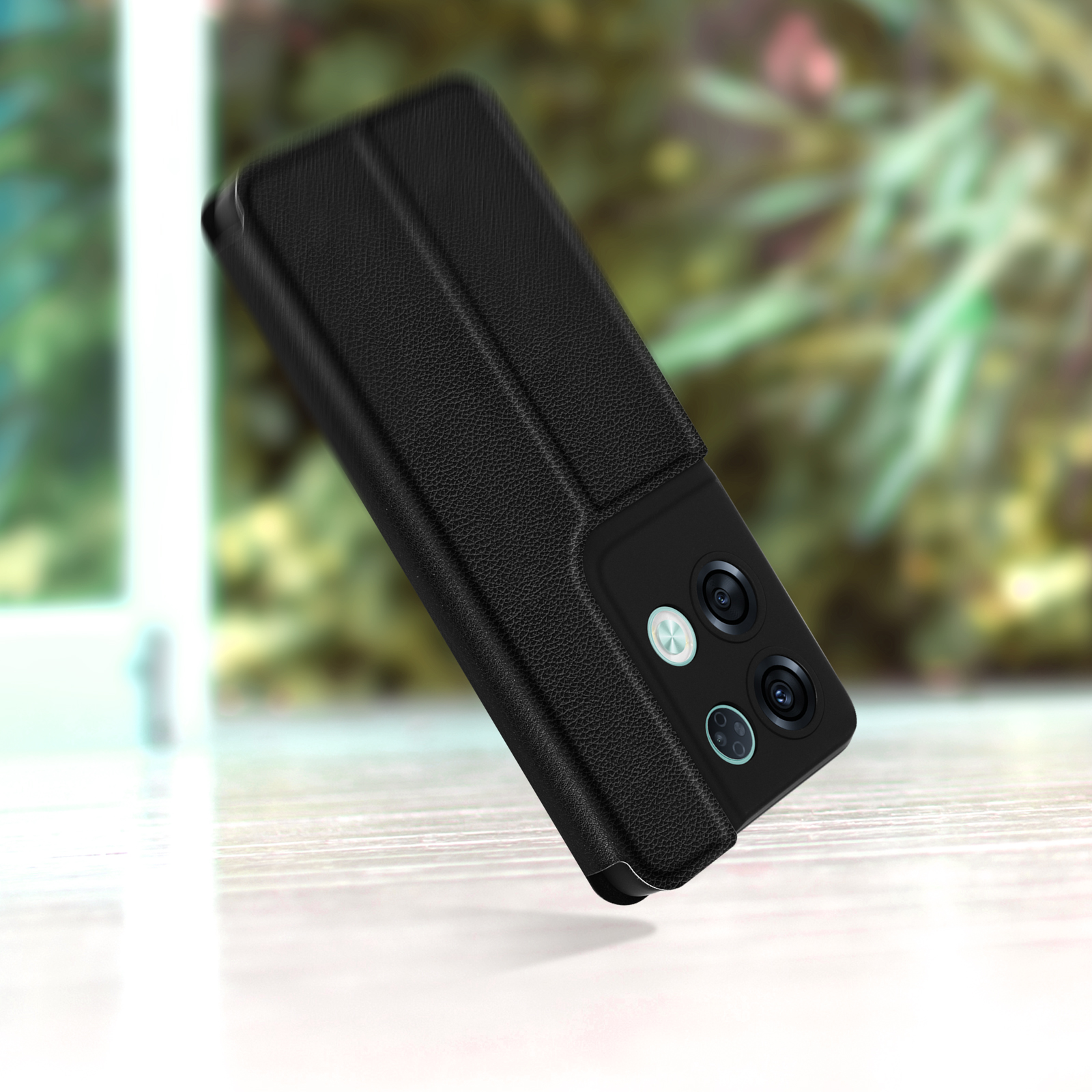Ein schwarzes Telefon in einer schwarzen Hülle, leicht angewinkelt, Kamera sichtbar.
