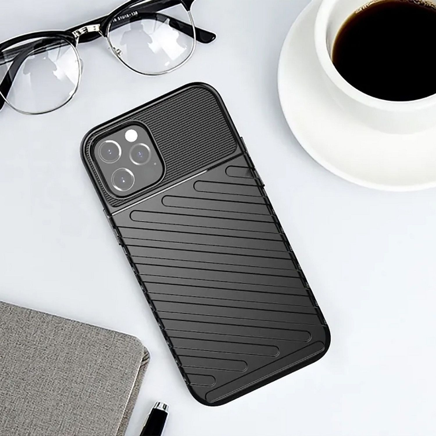 Schwarze Handyhülle auf weißer Oberfläche. Telefon, Brille und eine Kaffeetasse sind ebenfalls vorhanden.