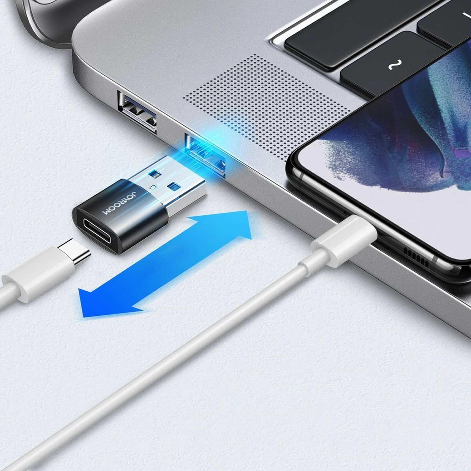 Laptop, der über einen USB-C-Adapter und ein weißes Kabel mit einem Telefon verbunden ist.