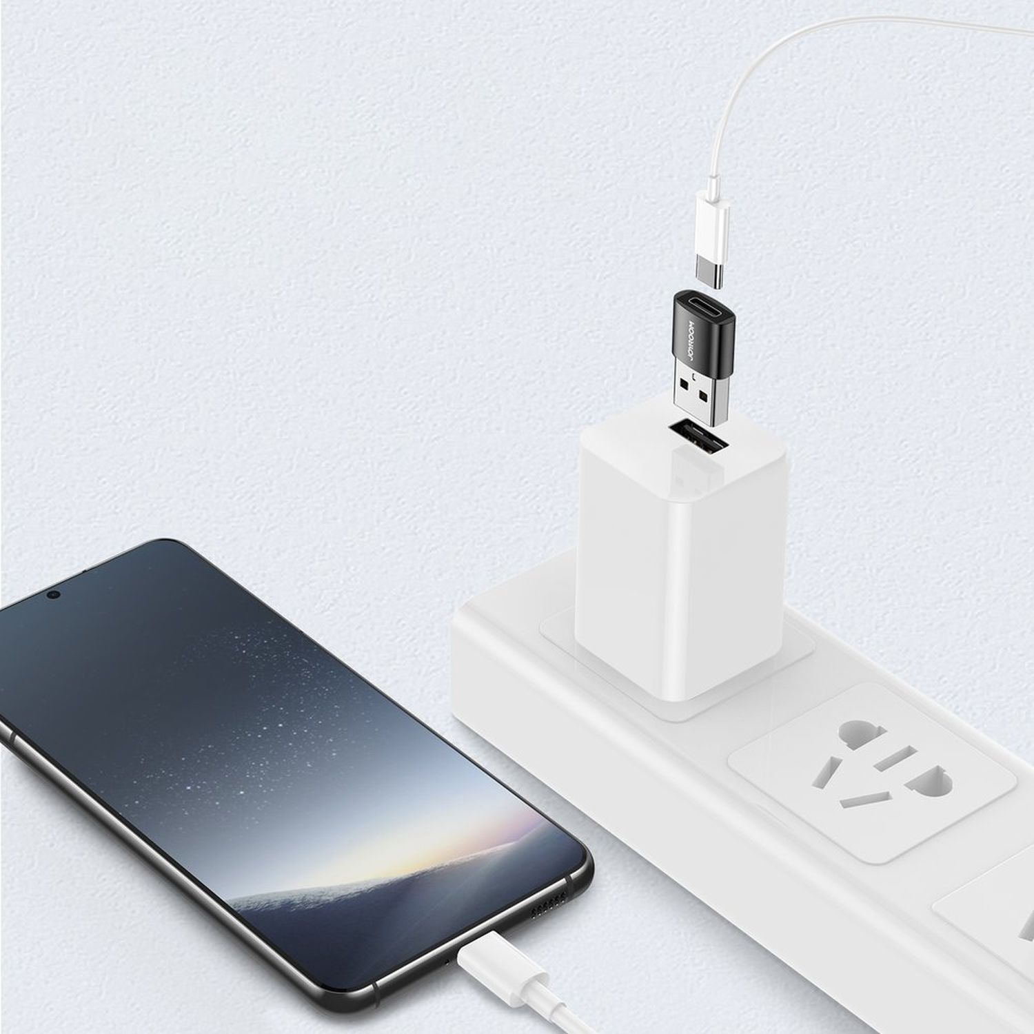 Telefon wird mit einem weißen Ladegerät und USB-C-Kabel aufgeladen, das in eine Steckdose gesteckt ist.